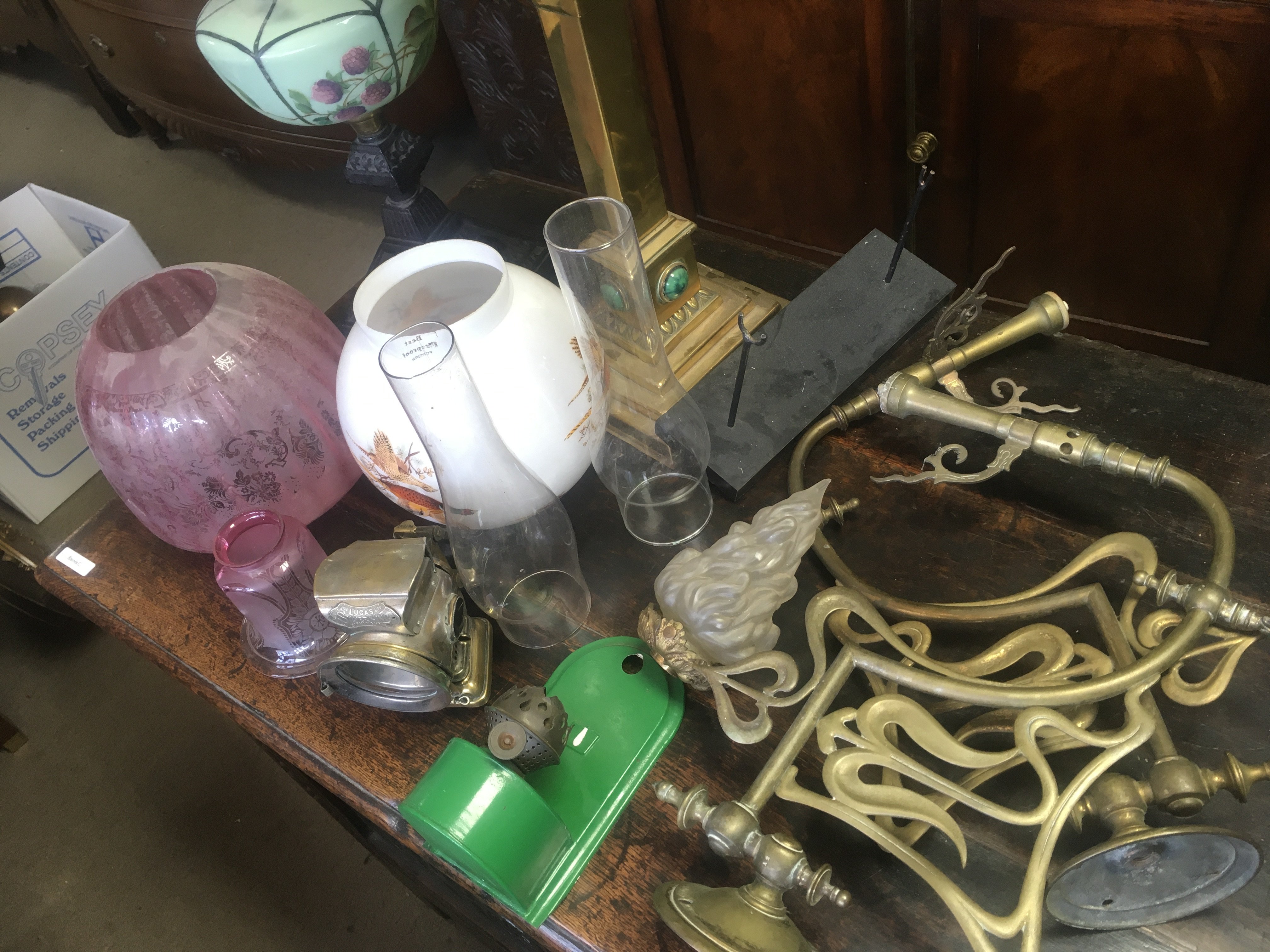A Collection of oil lamps parts shades and funnels together with a pair of Art Nouveau style gas brackets.