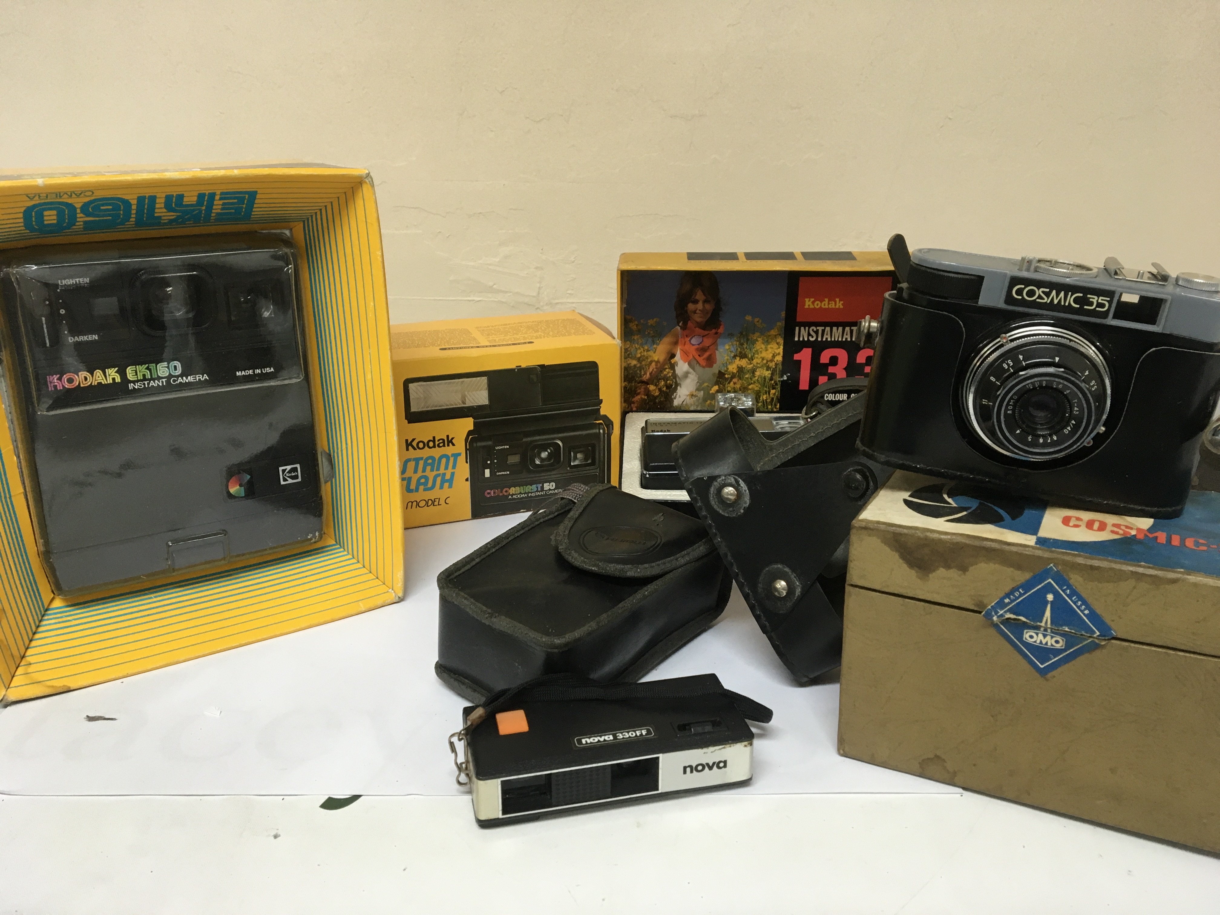 A collection of Vintage cameras boxed and as new Kodak Instamatic 133 Kodak EK160 instant flash Model C a Cosmic 35 with box and other cameras.