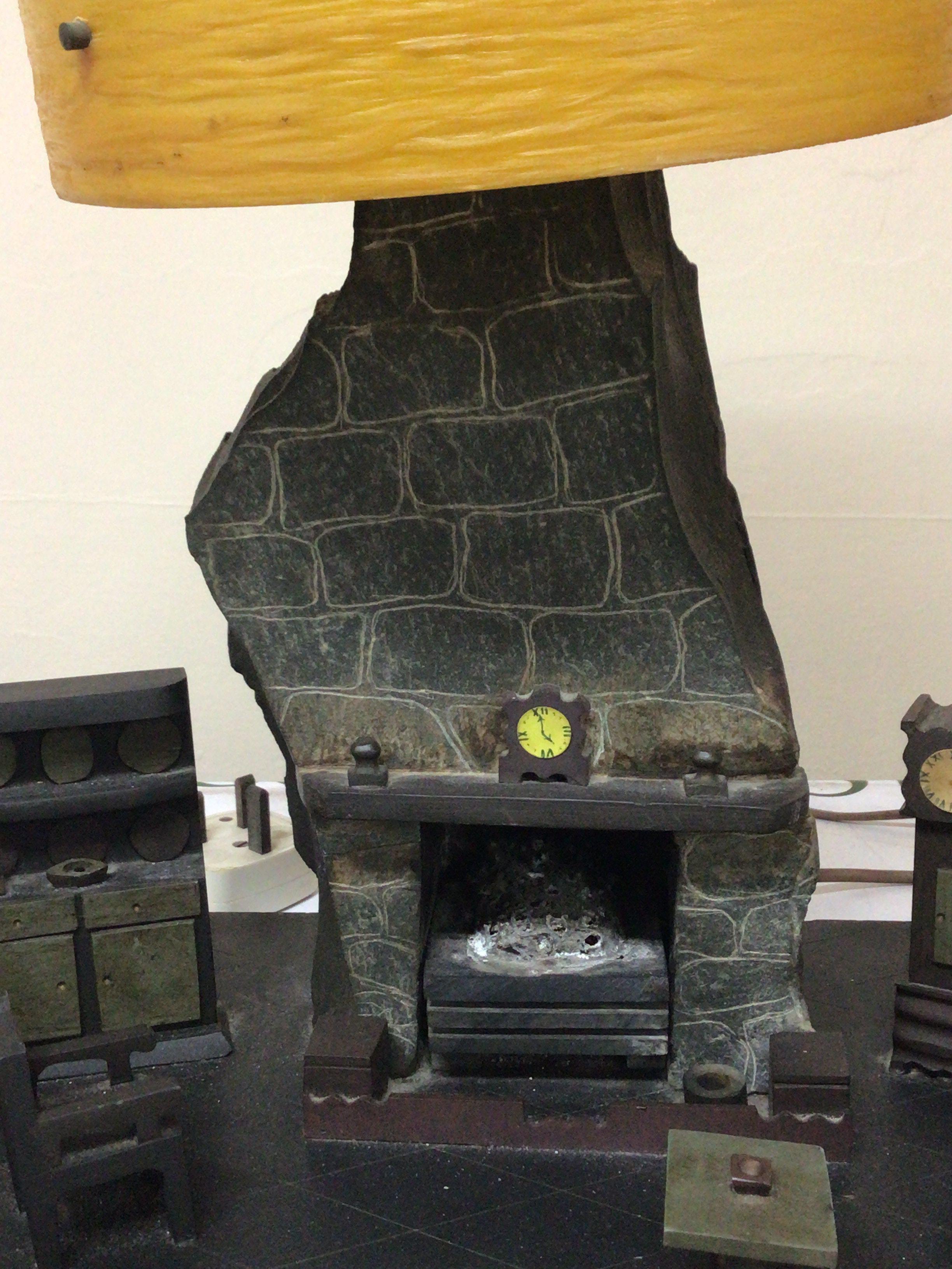 A Mid 20th Century welsh slate sculpture an interior scene with a fireplace and furniture the top with a lamp. Hight 43cm width 36cm- NO RESERVE