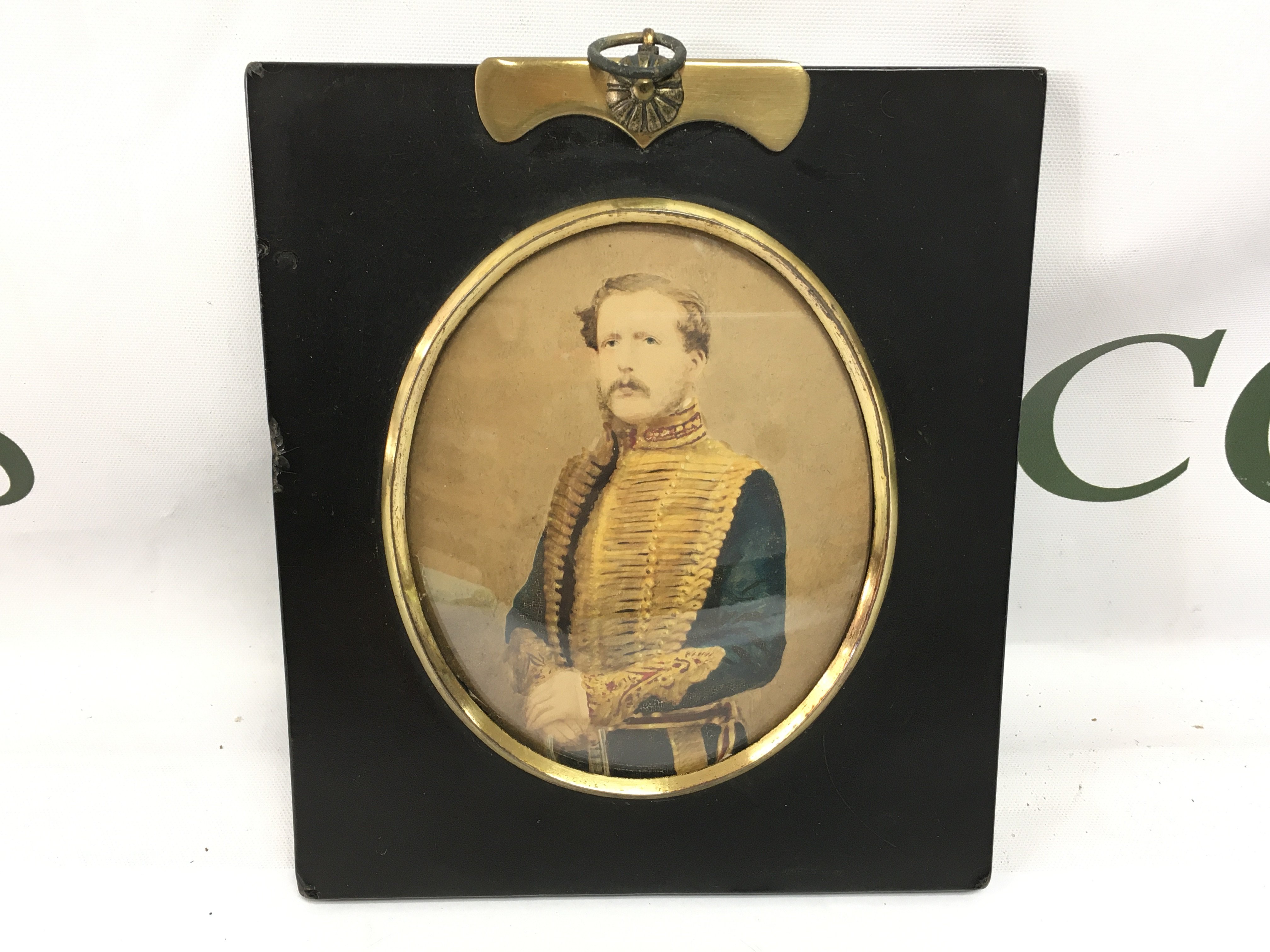 A framed ebonised photograph portrait of a gentleman in military dress.