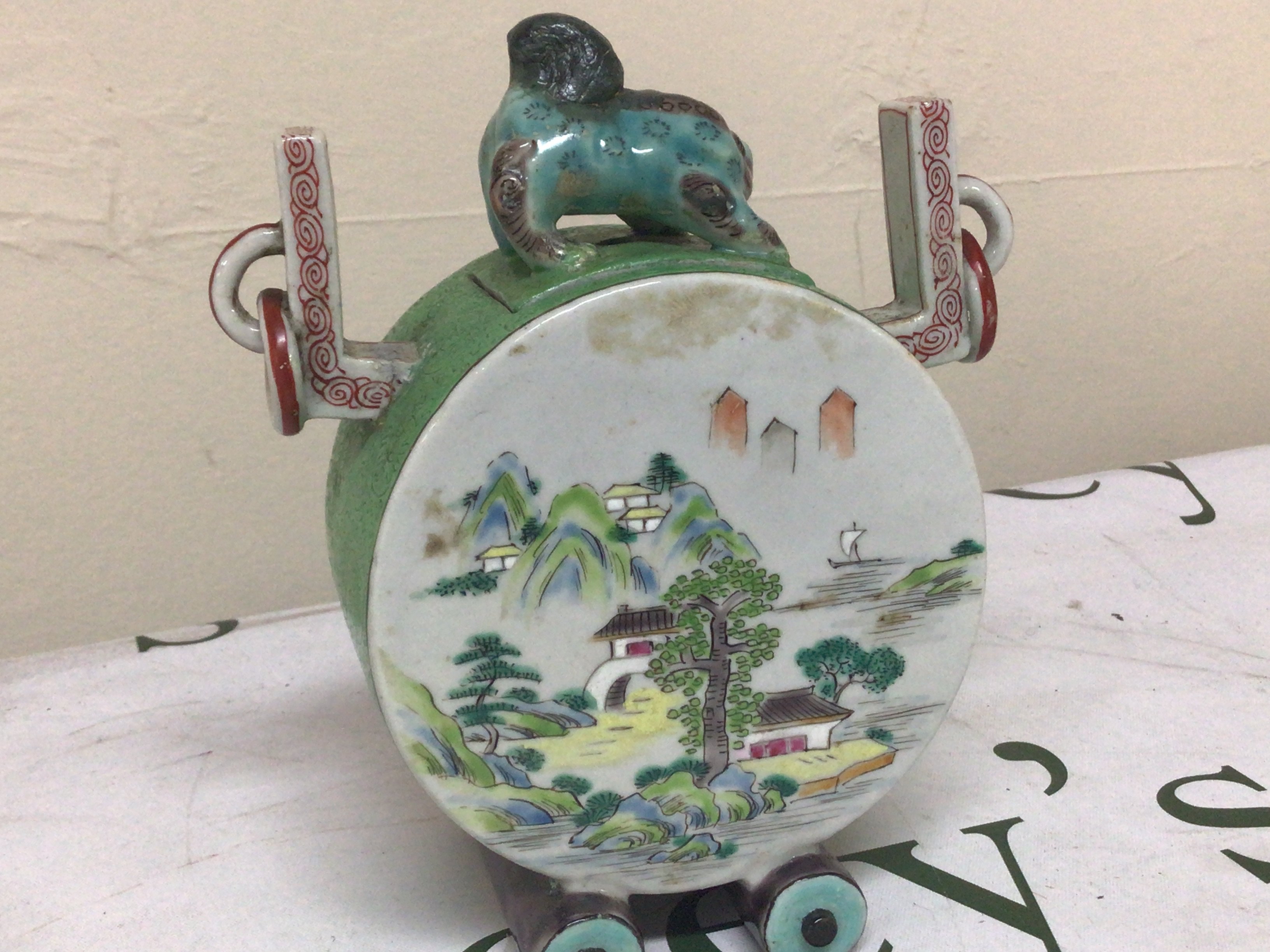 A Chinese porcelain drum shaped incense vase the cover surmounted with a temple dog flanked by raised ring ornamentations. Polychrome decoration with figures and landscape. Character marks to the base. Height 17cm- NO RESERVE