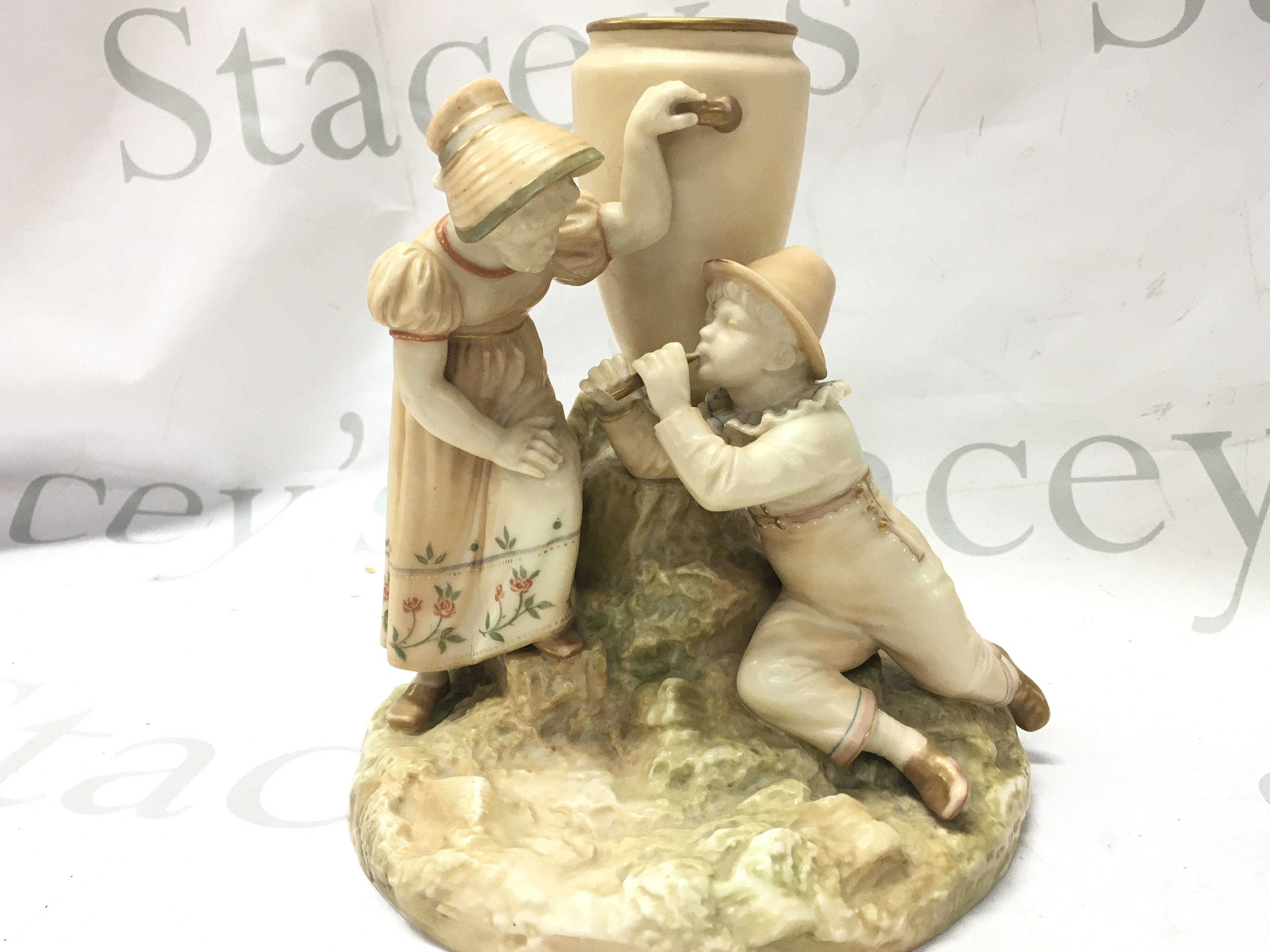 A Royal Worcester blush ivory vase of two children beside an urn, 18cm high.this lot cannot be posted