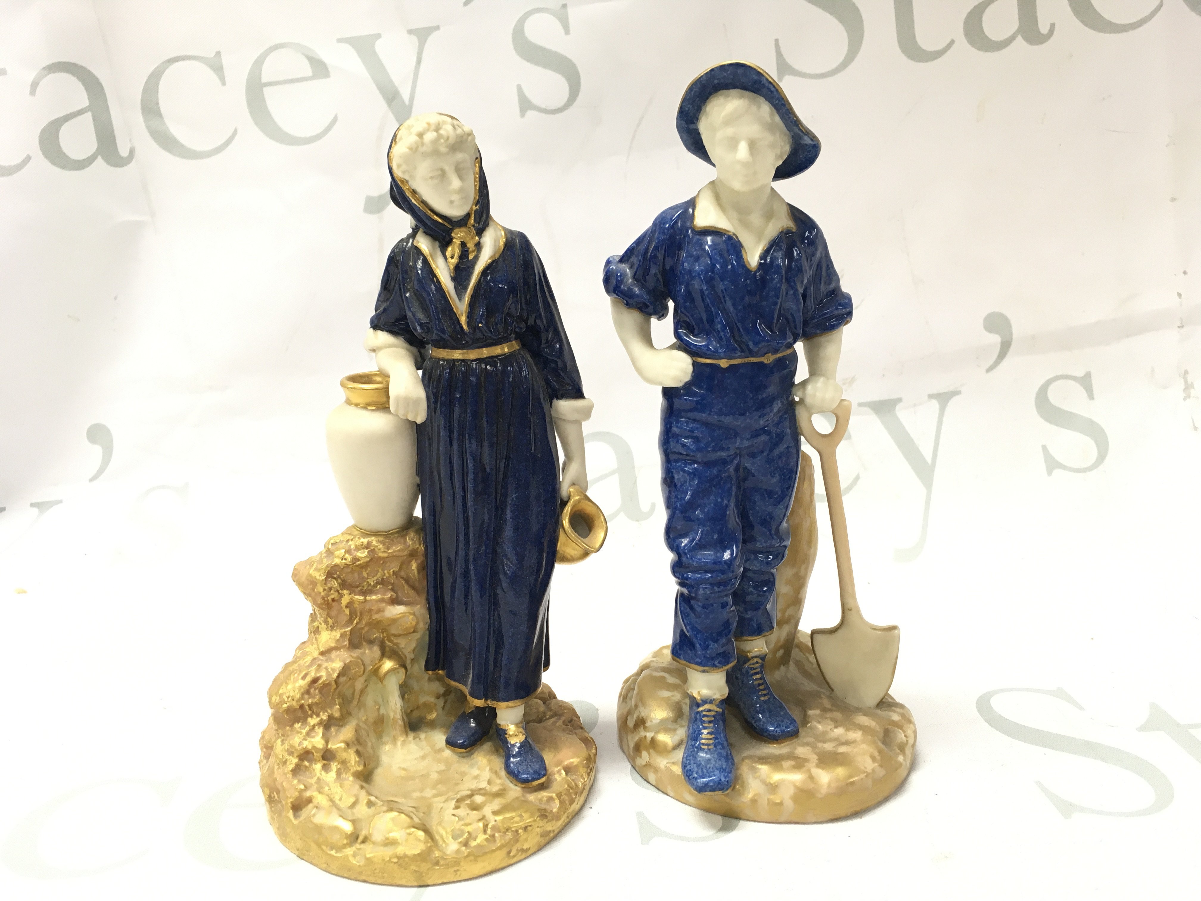 A pair of Royal Worcester porcelain powder blue glazed James Hadley Farmer couple figures , dated 1810.
