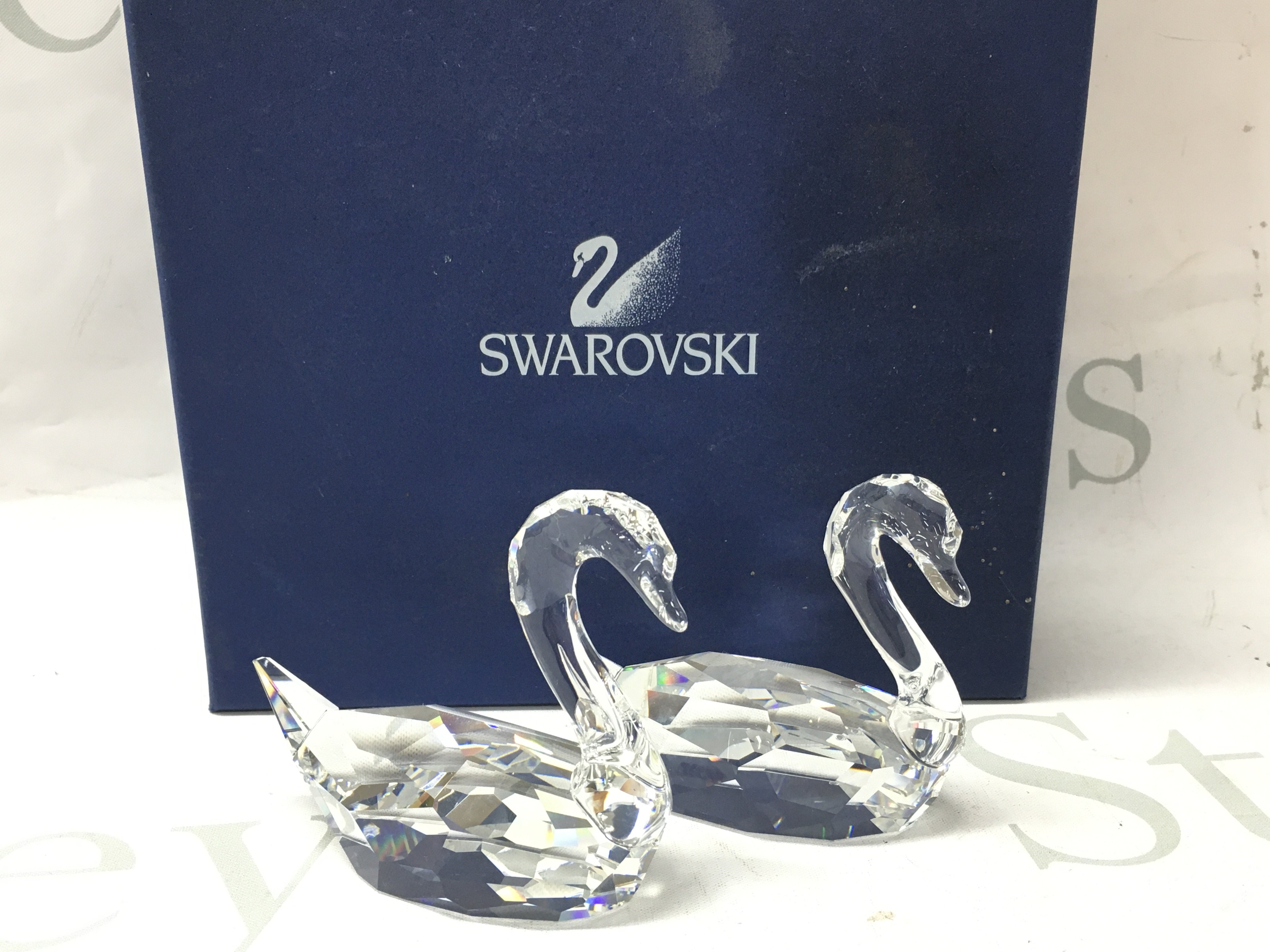 A boxed pair of Swarovski cut crystal glass swan figures. This lot cannot be posted
