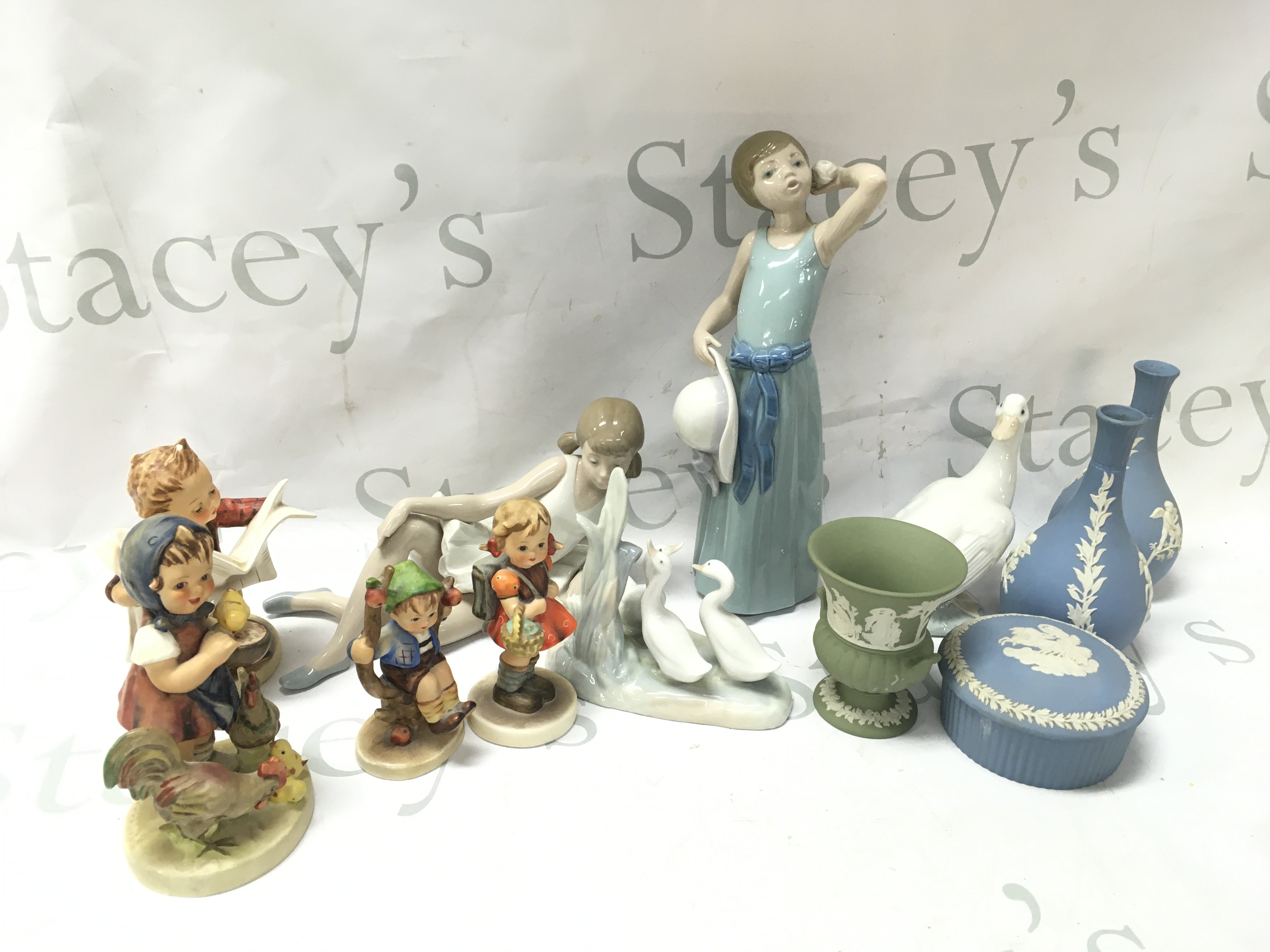A collection of ceramic figures including Lladro, Hummel, Wedgwood vases and a trinket box . This lot cannot be posted