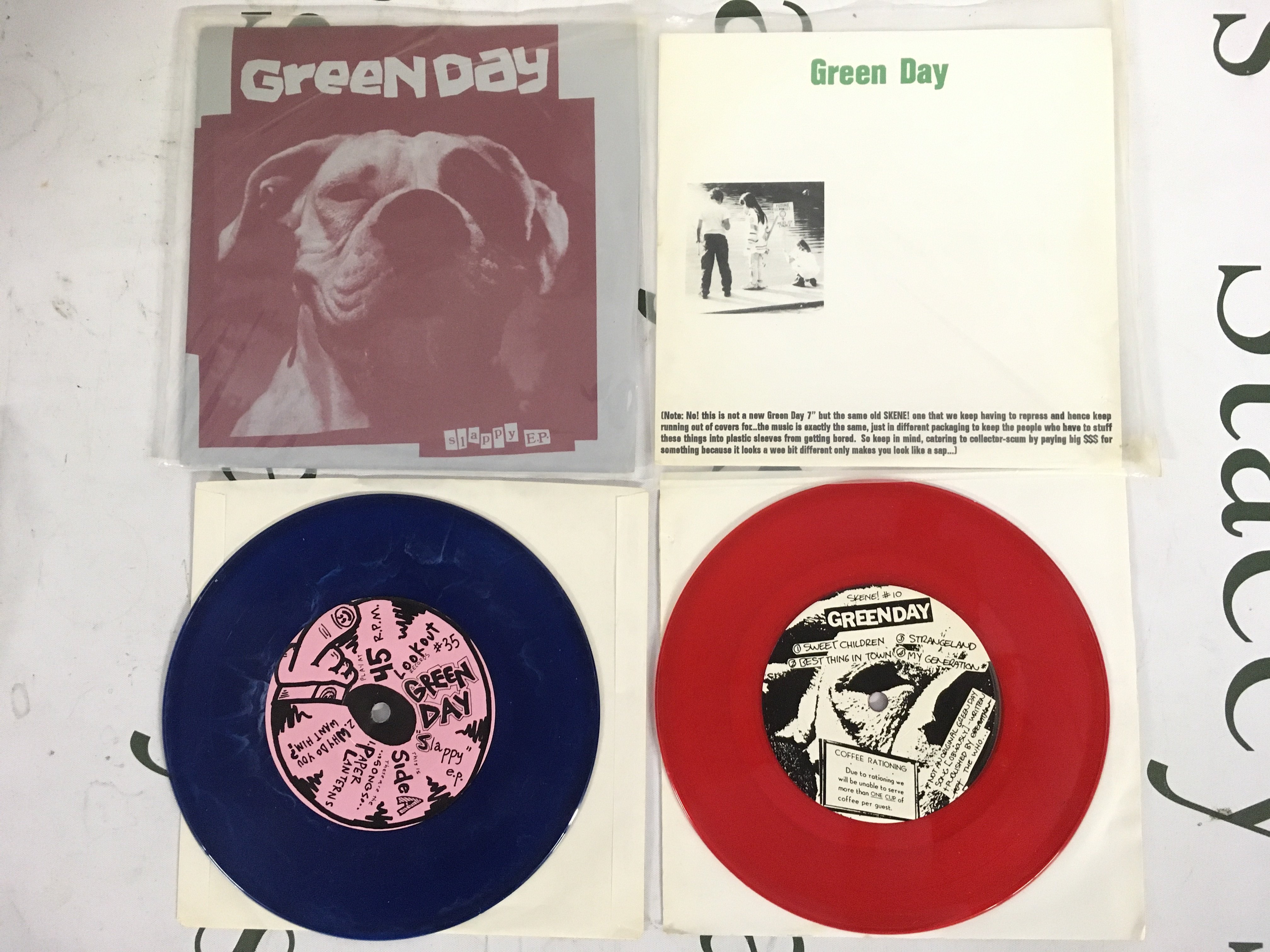 Two coloured vinyl Green Day EPs comprising a first US pressing of the Slappy EP on blue marbled vinyl plus a pink vinyl pressing of Sweet Children. Both EX/EX.