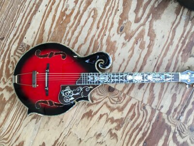 A 2005 Antonio Tsai guitar with a mandolin body shape and intricate mother of pearl inlaid decoration. Some small areas missing inlay. Comes with original hard carry case.