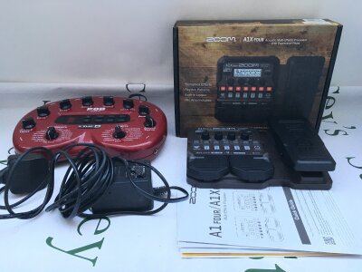 A boxed Zoom A1X Four acoustic multi effects processor with expression pedal plus a Line 6 Pod V2 with PSU (2).