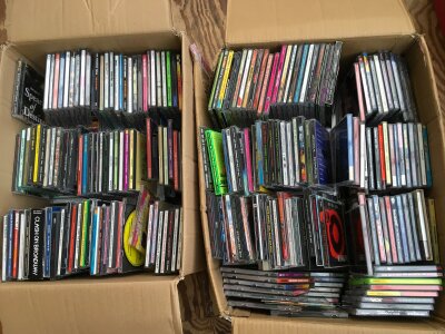 Three boxes of CDs, DVDs and VHS tapes by various artists including Sex Pistols, Toy Dolls, Gwar, Sonic Youth and many more.