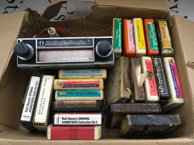 A small collection of 8 track cartidges and an in car 8 track player.
