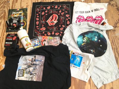A collection of music memorabilia including Rolling Stones concert merchandise, band t shirts etc.