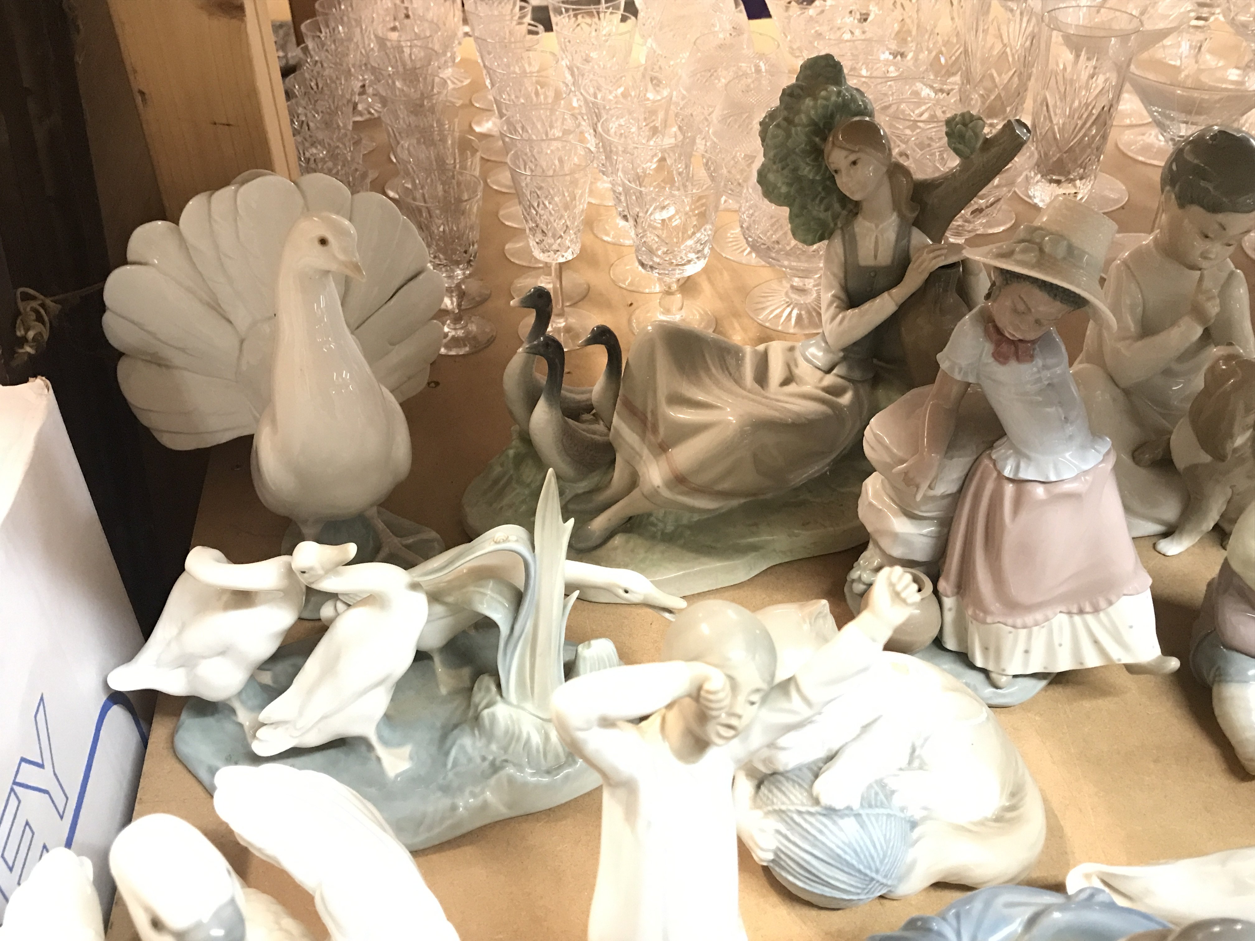 A Collection of Lladro and Nao figures including dog in a basket, dove, girl with geese(damaged) etc. this lot cannot be posted