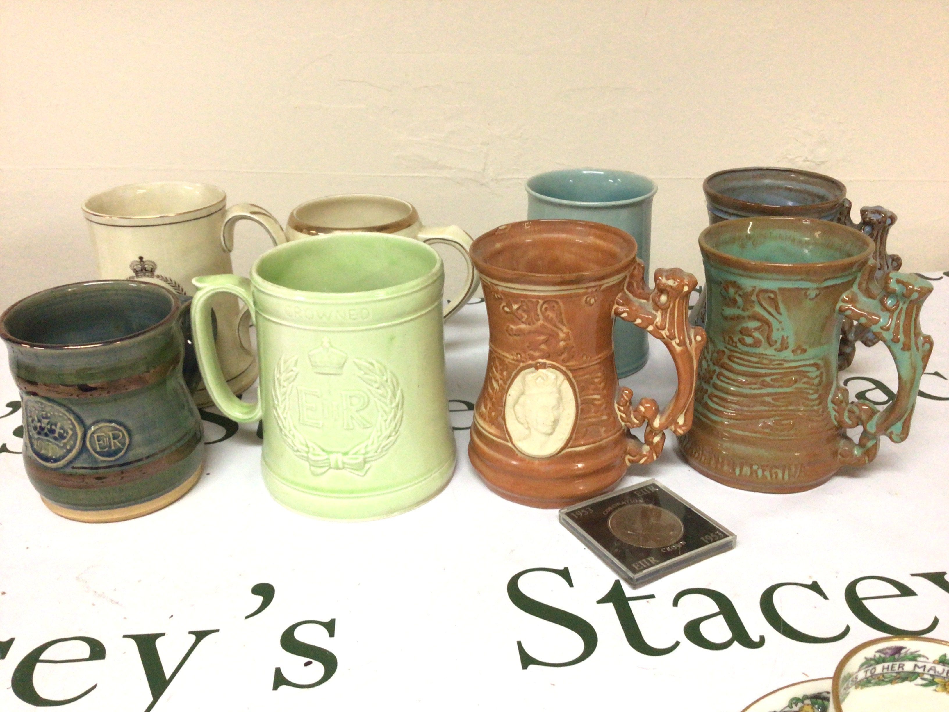 A collection of Elizabeth II coronation commemorative ceramic mugs.- NO RESERVE