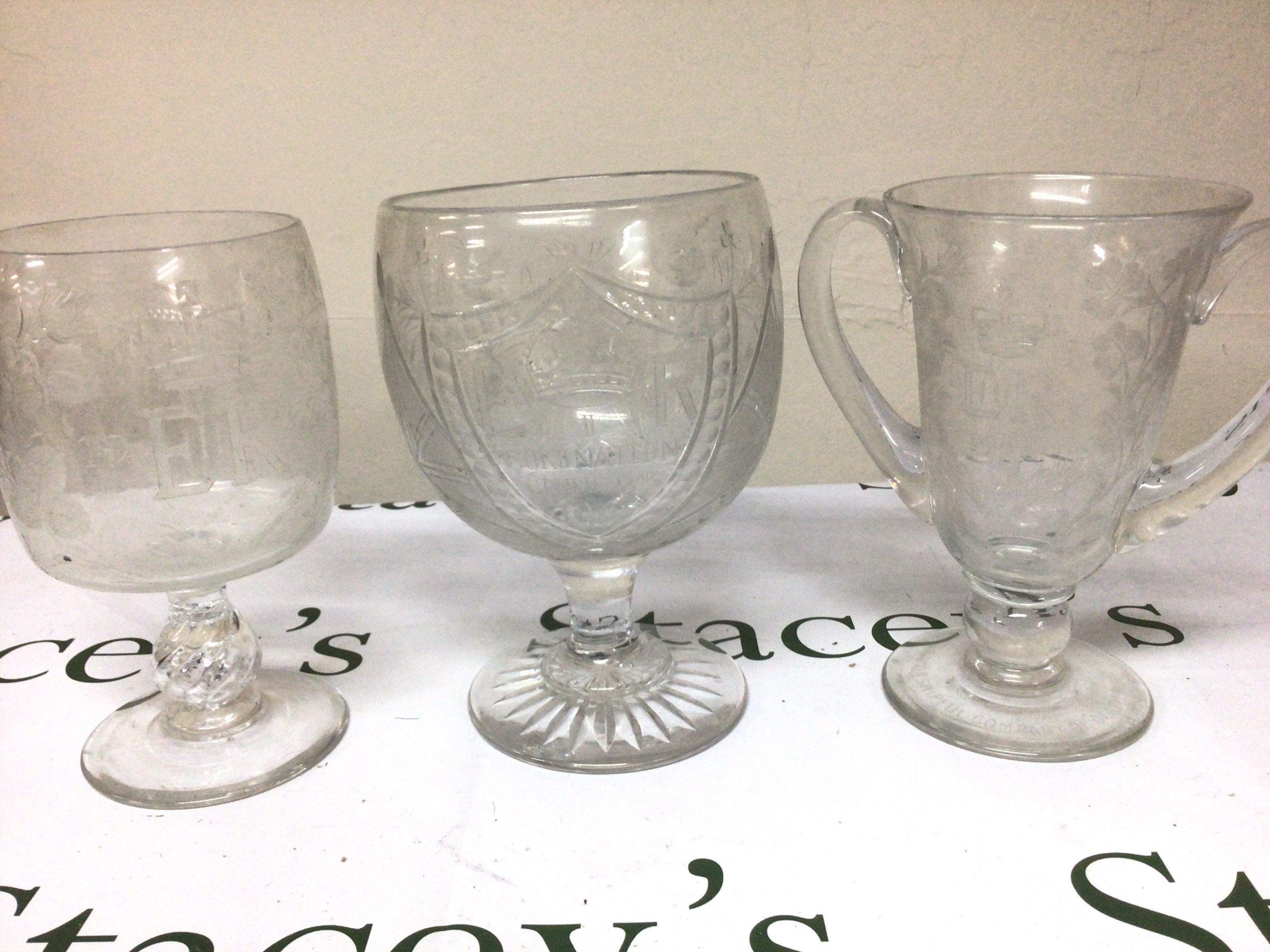 Three cut glass wheel and etched glass goblets of large size engraved with the cypher of Elizabeth II and conforming ornamentation. Hight 22cm no obvious damage. NO RESERVE.