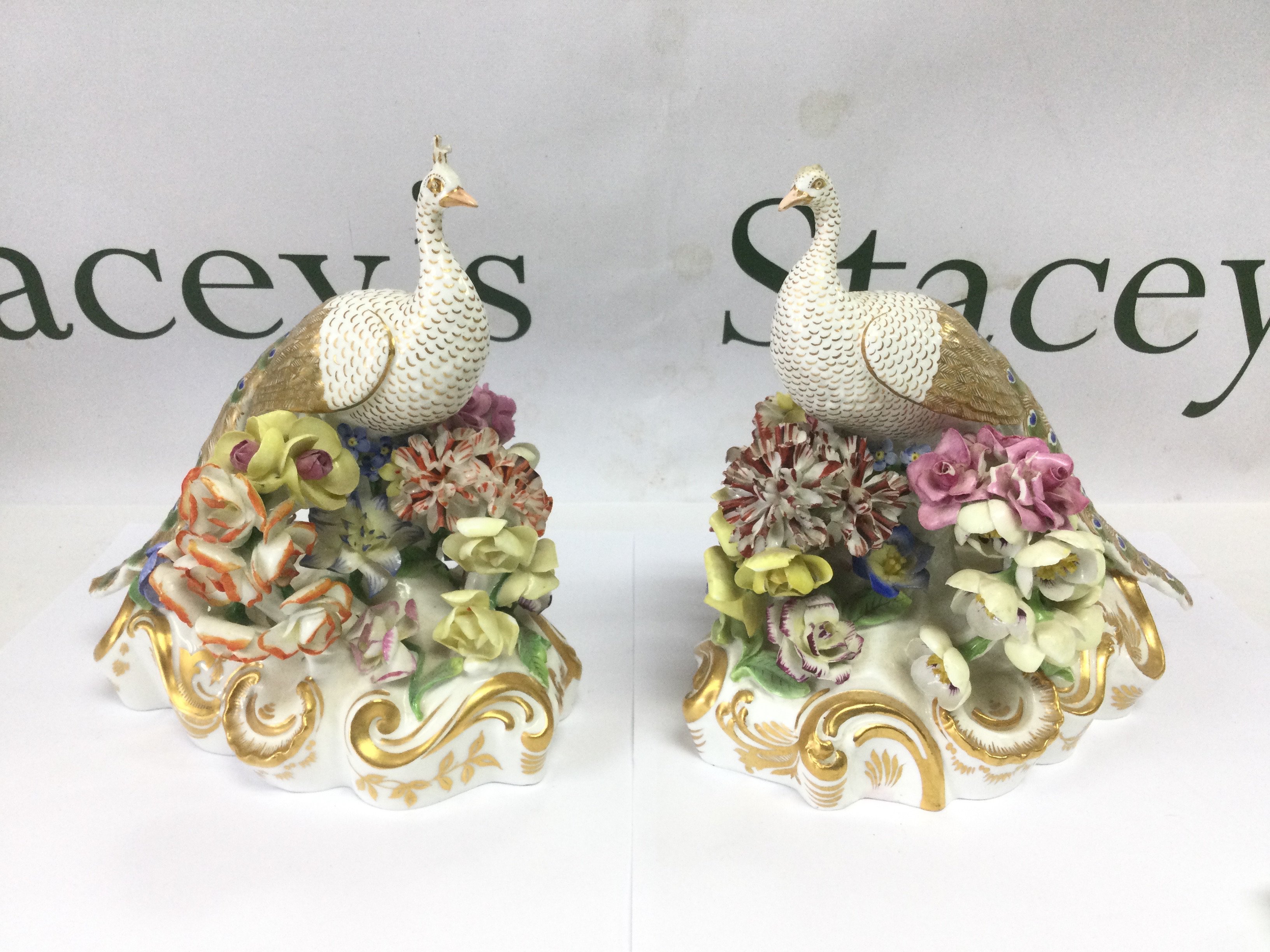A pair of fine quality Crown Derby figures of peacocks with encrusted floral decoration, a/f. Approx height 16cm. Shipping category D.