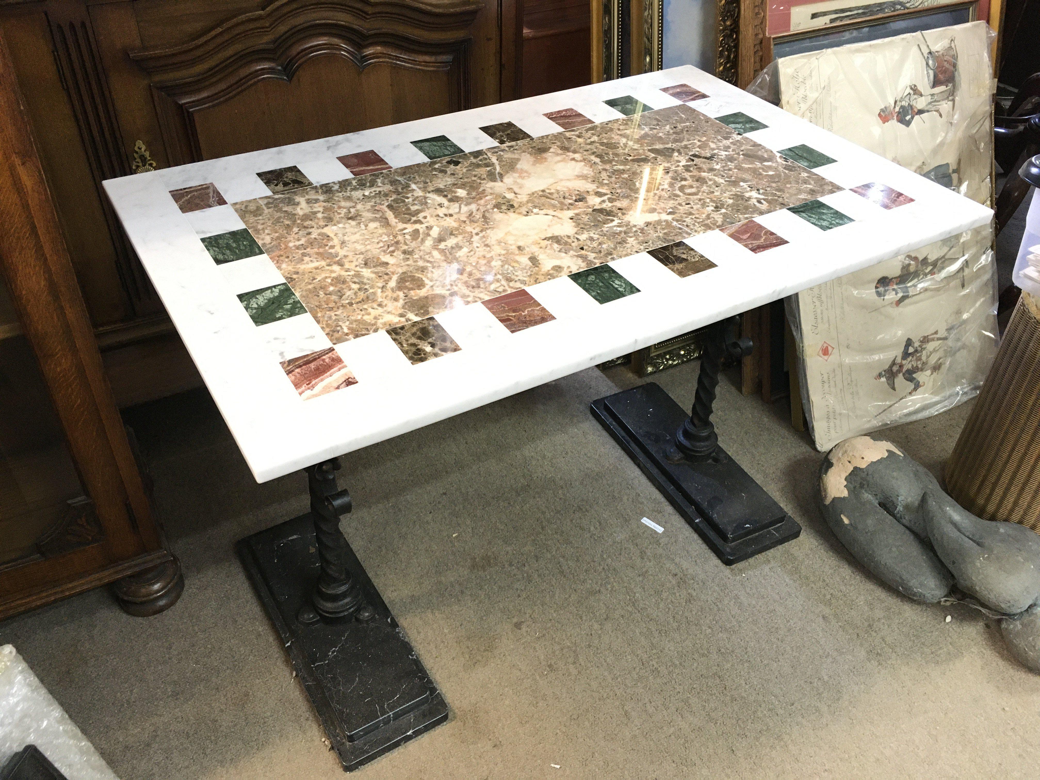 A marble top table with cast iron legs , 90cm wide, 60cm tall.