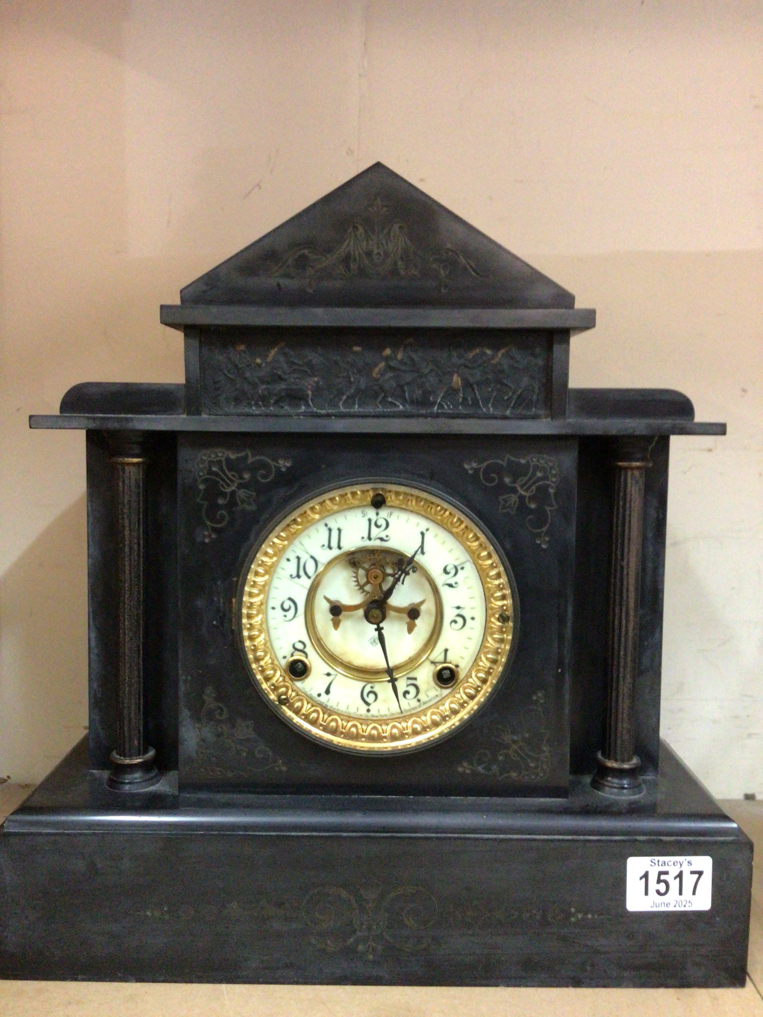 A black slate mantel clock having Roman numerals and visible escapement. NO RESERVE