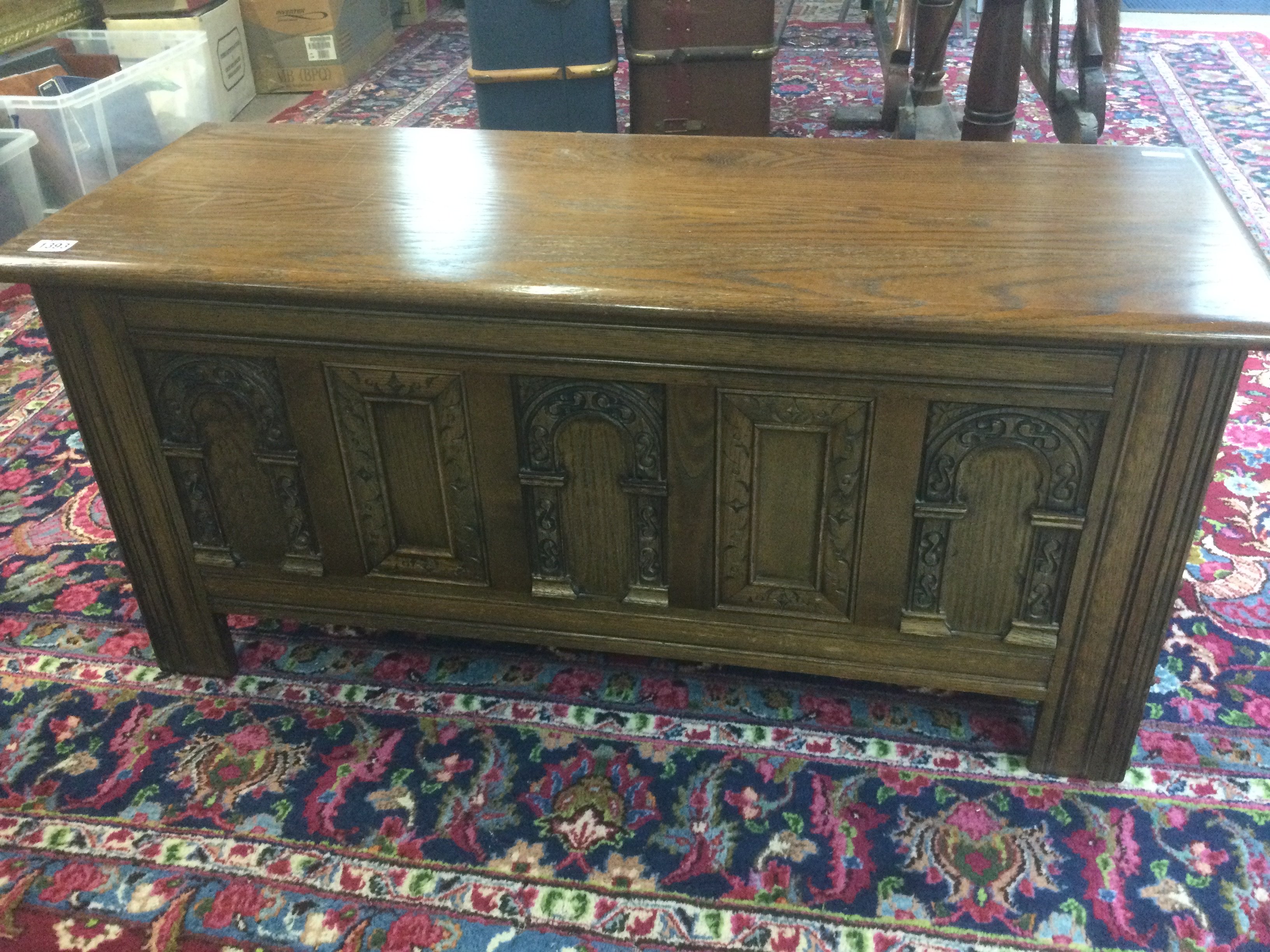 A oak blanket box with carved panel front .