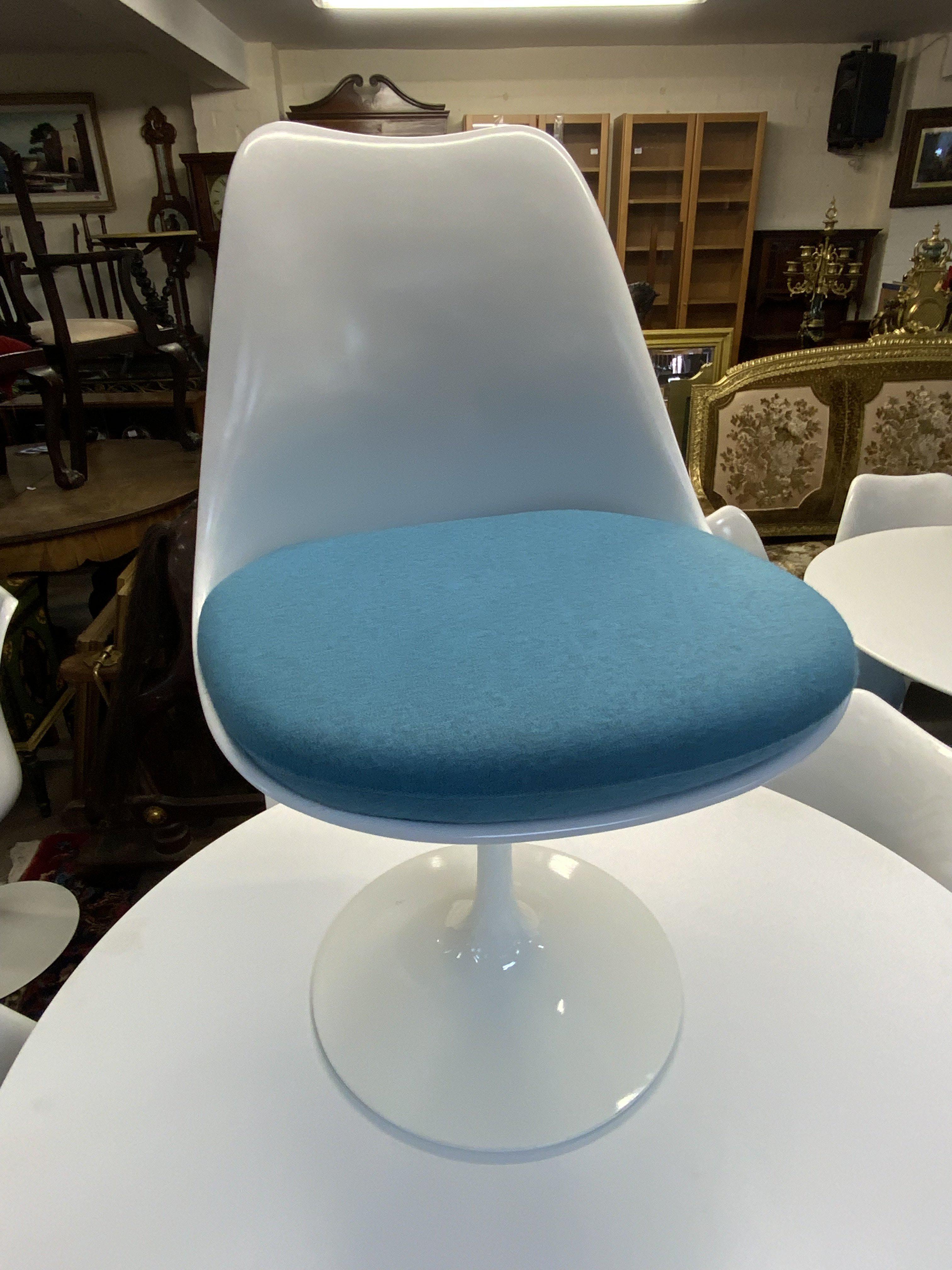 Mid Century Tulip dining suite (Table and 6 chairs) designed by Eero Saarinen 1956 (Finnish-American, 1910-1961) for Knoll, laminated top over a curved painted metal base, stamped 'Knoll Studio', 107cm diameter 73cm high, and six 'Tulip' chairs, each with a white plastic shell over a painted metal base. (Mixed Light blue / turquoise blue upholstered cushions).