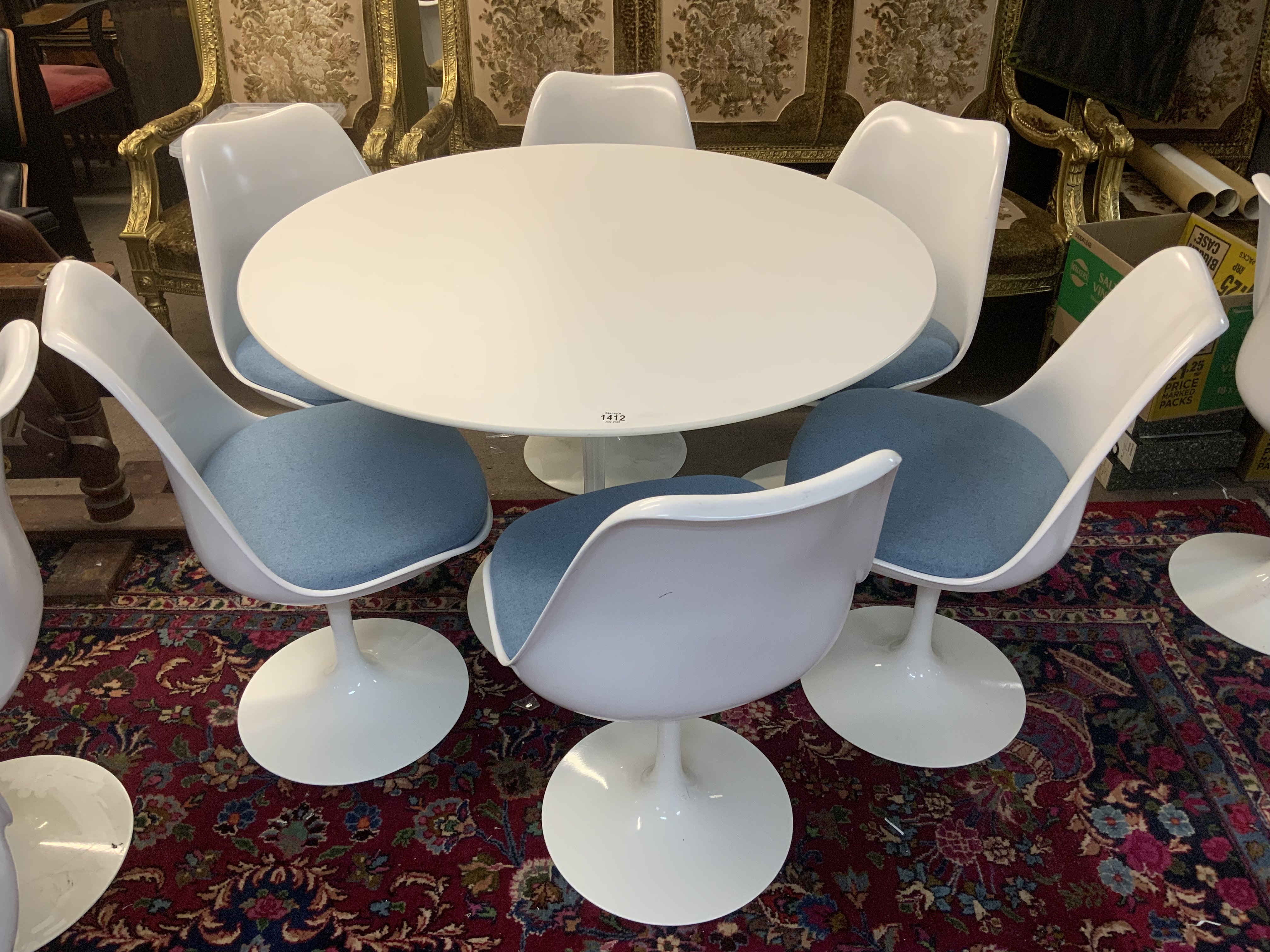 Mid Century Tulip dining suite (Table and 6 chairs) designed by Eero Saarinen 1956 (Finnish-American, 1910-1961) for Knoll, laminated top over a curved painted metal base, with label 'Knoll Studio', 107cm diameter 73cm high, and six 'Tulip' chairs, each with a white plastic shell over a painted metal base. (Light blue upholstered cushions).