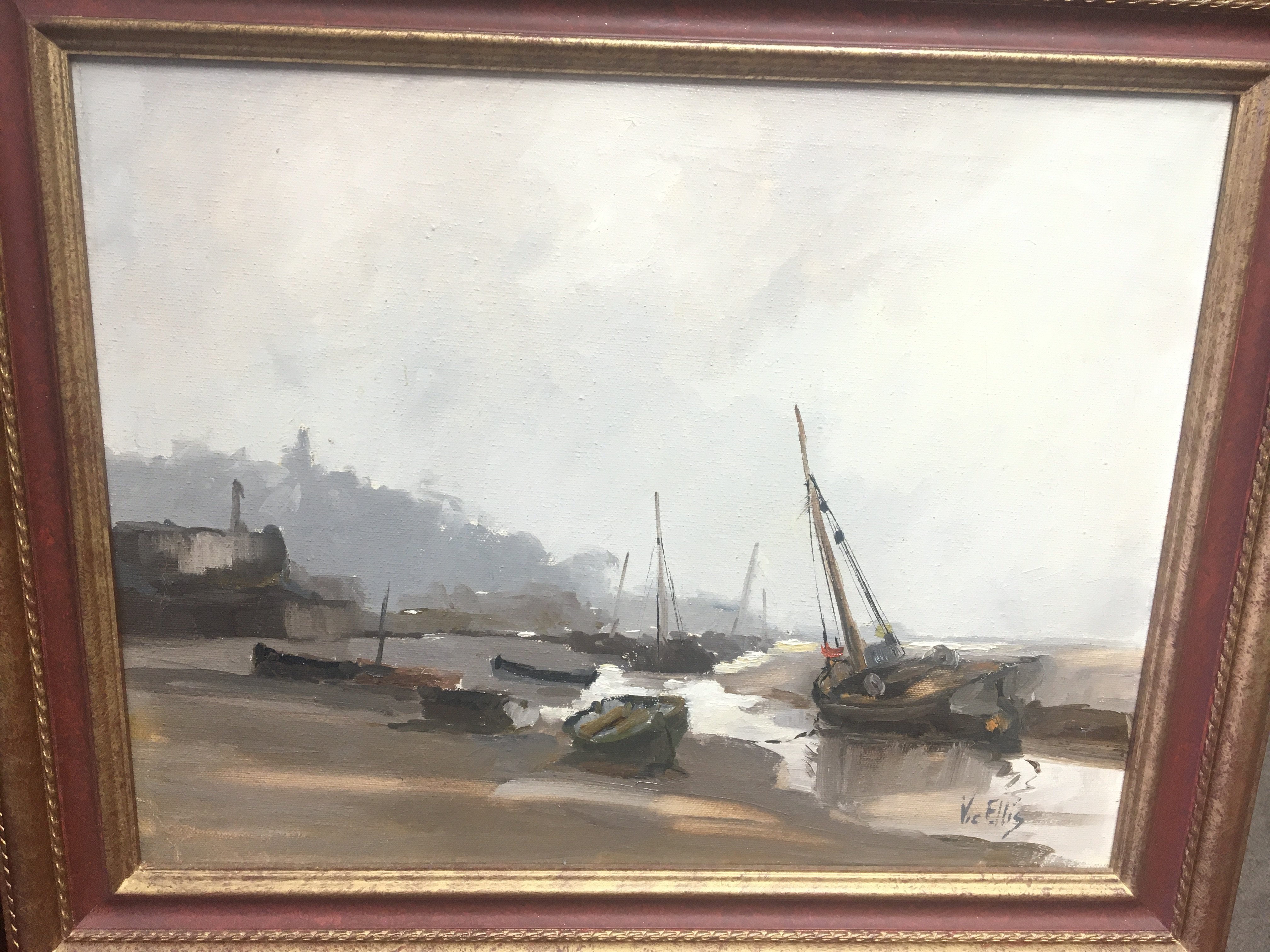 A framed Vic Ellis oil on board depicting boats in harbour. 58x49cm