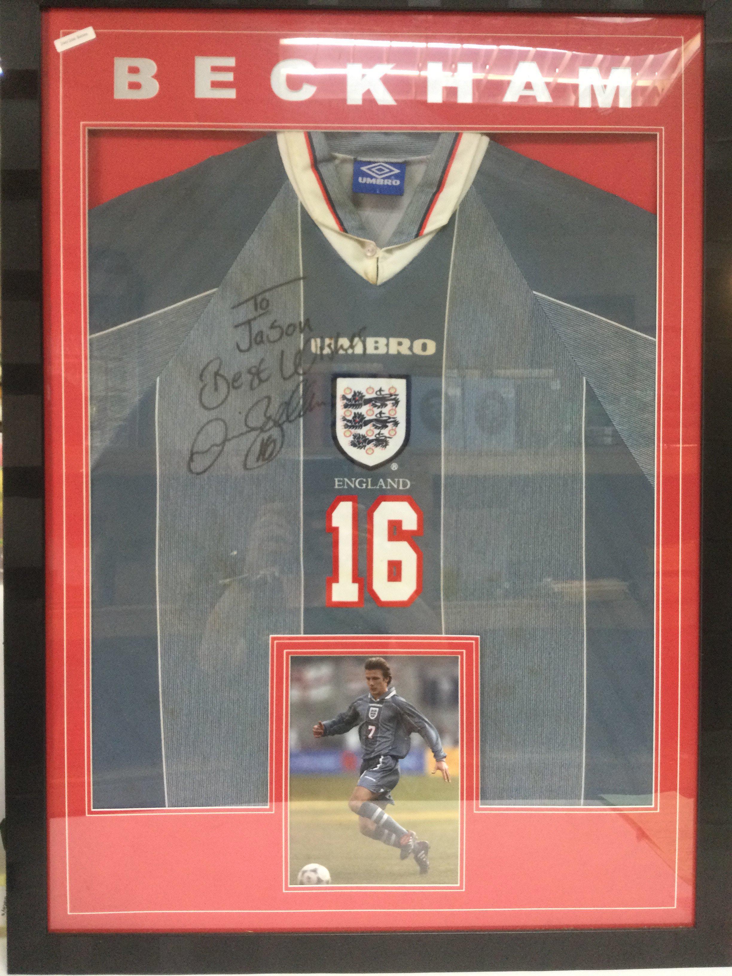 A framed and glazed 1998 England away shirt signed by David Beckham, approx 73cm x 98cm. Shipping category D.