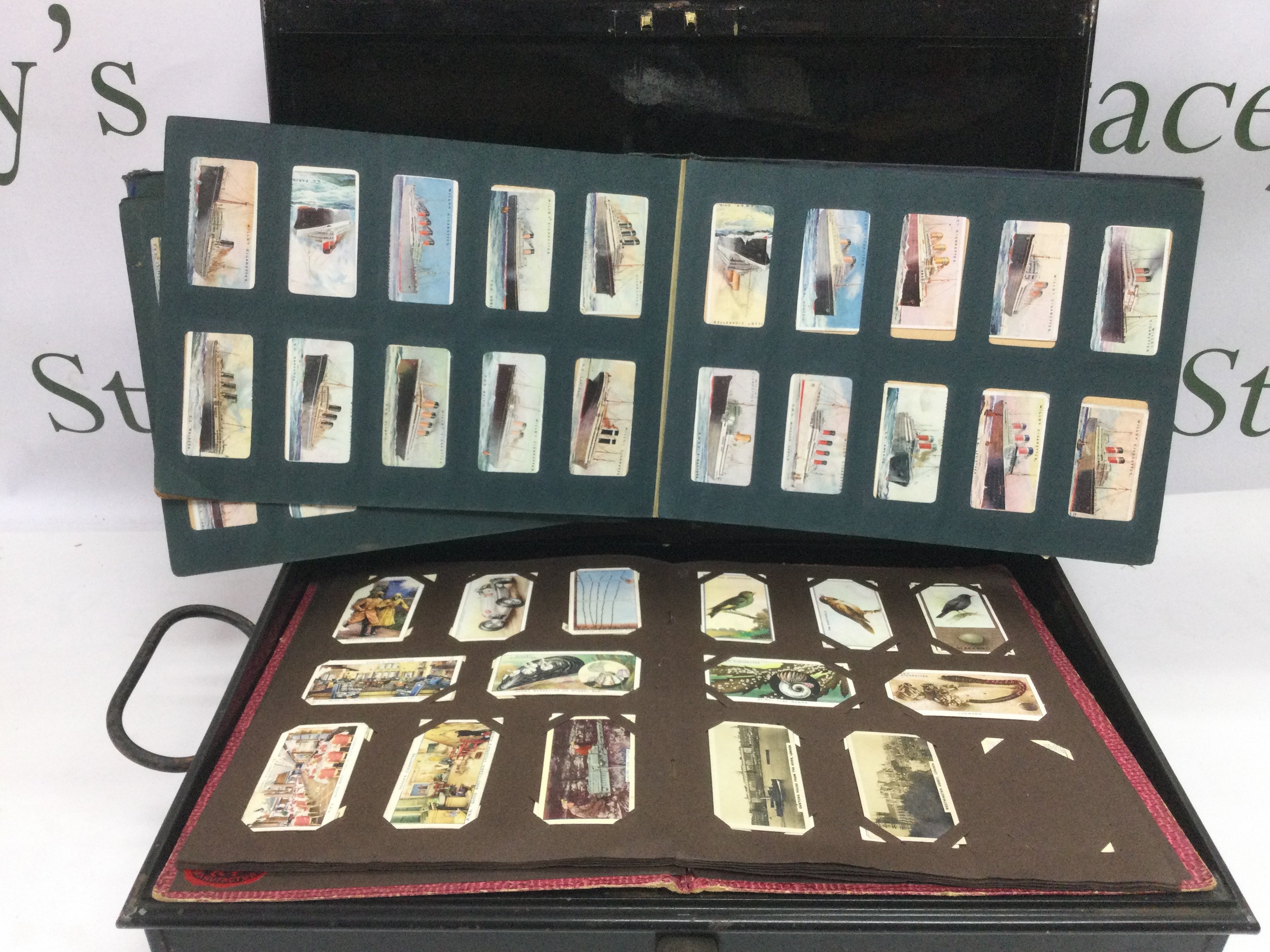 A tin containing a collection of cigarette cards, loose and in albums. Shipping category D.