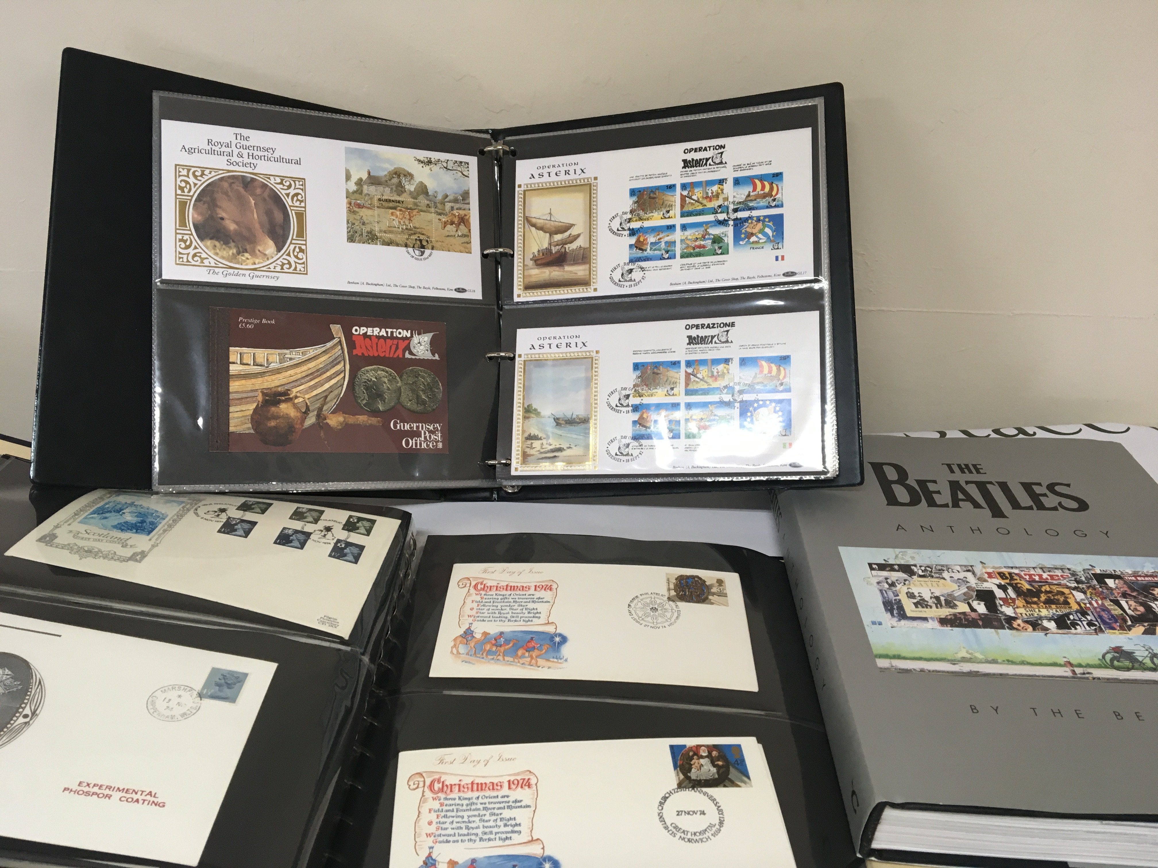 A box containing well presented first day covers in albums the Beatles Anthology and other books