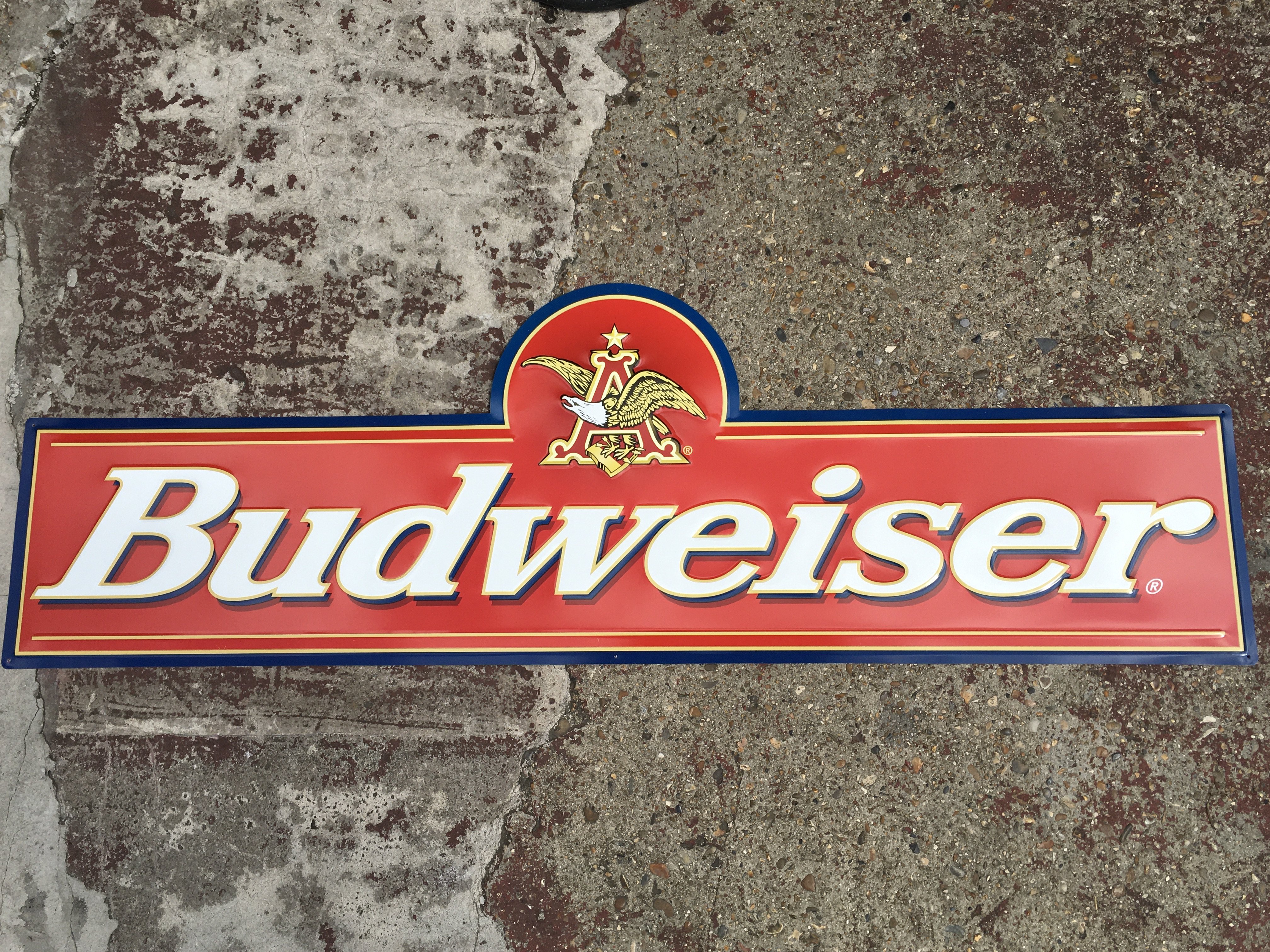 A vintage Budweiser embossed advertising sign , 117cm long x38cm tall