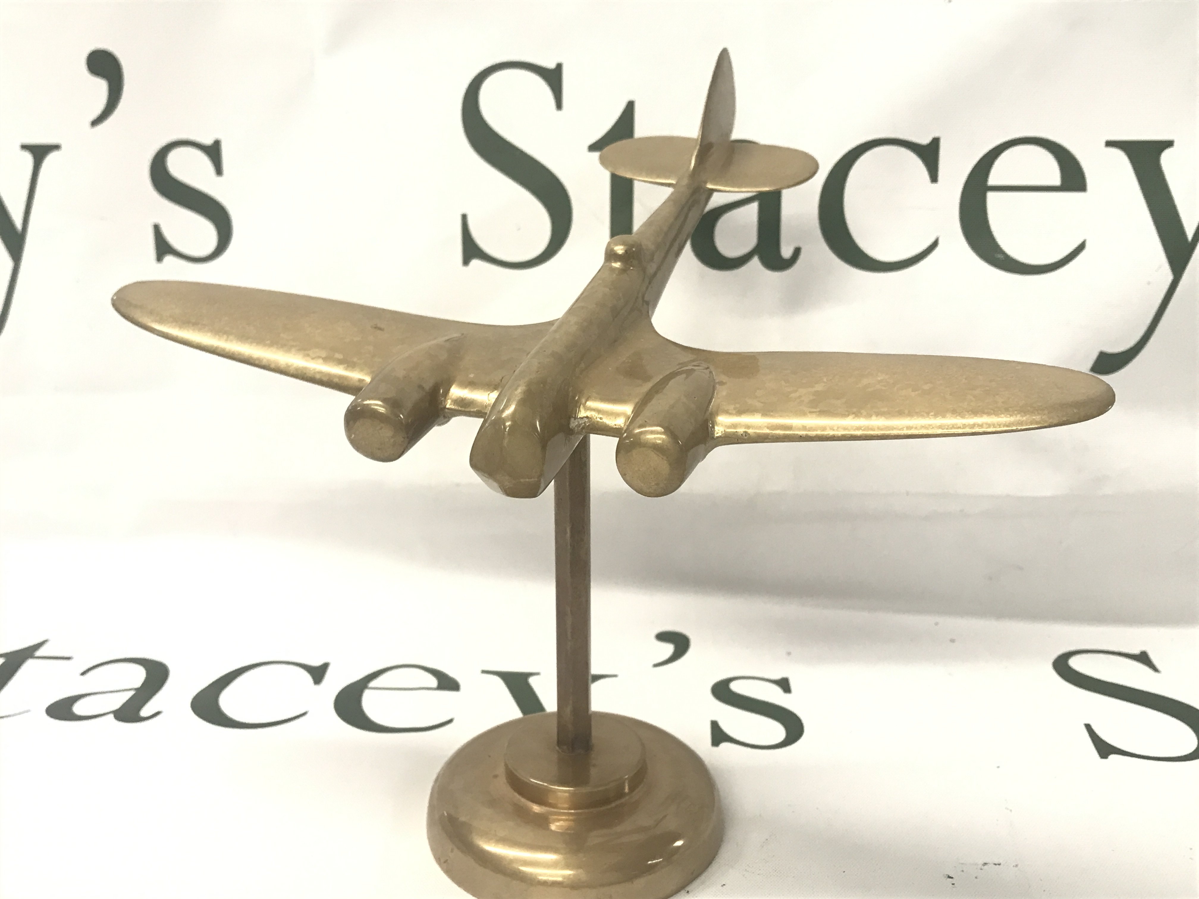 A solid brass aeroplane and stand , postage category B