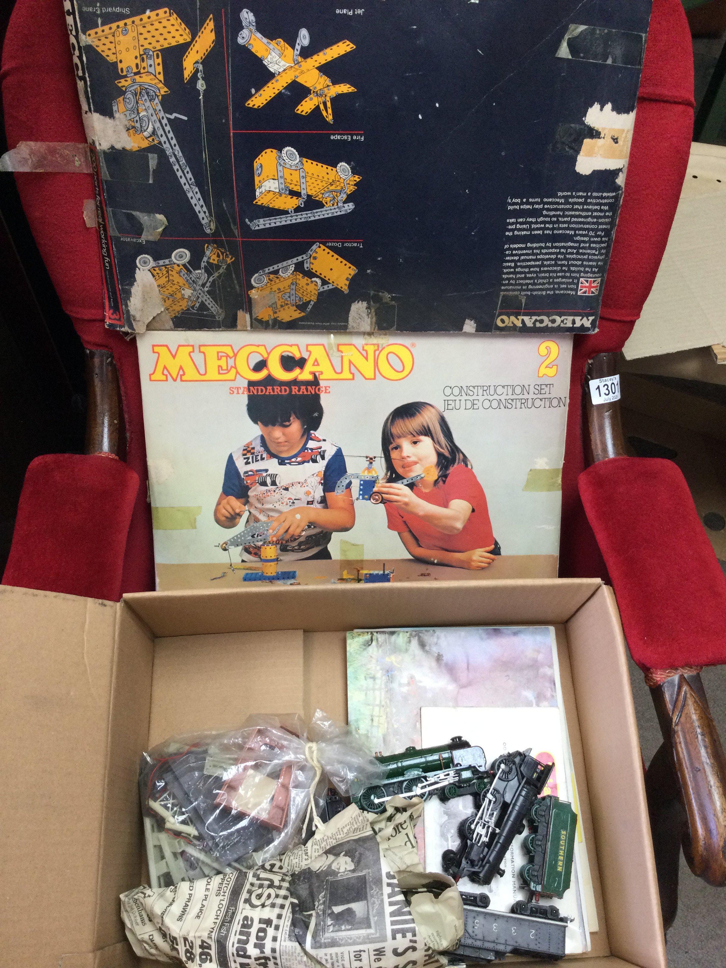 A box of trains and Meccano, with some track and station buildings