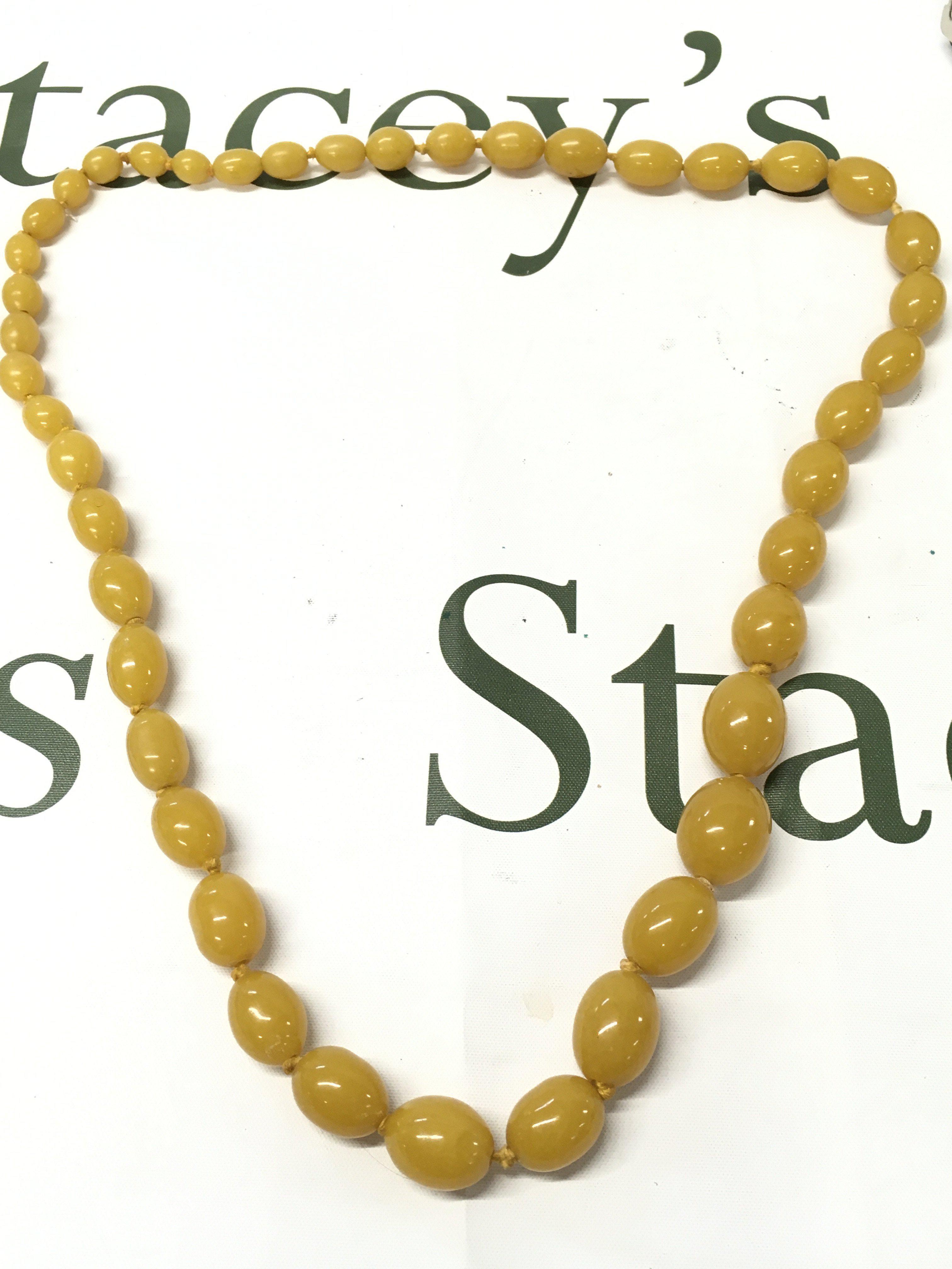 A butterscotch bakelite amber necklace , 80cm long, 100g total weight. Postage category A