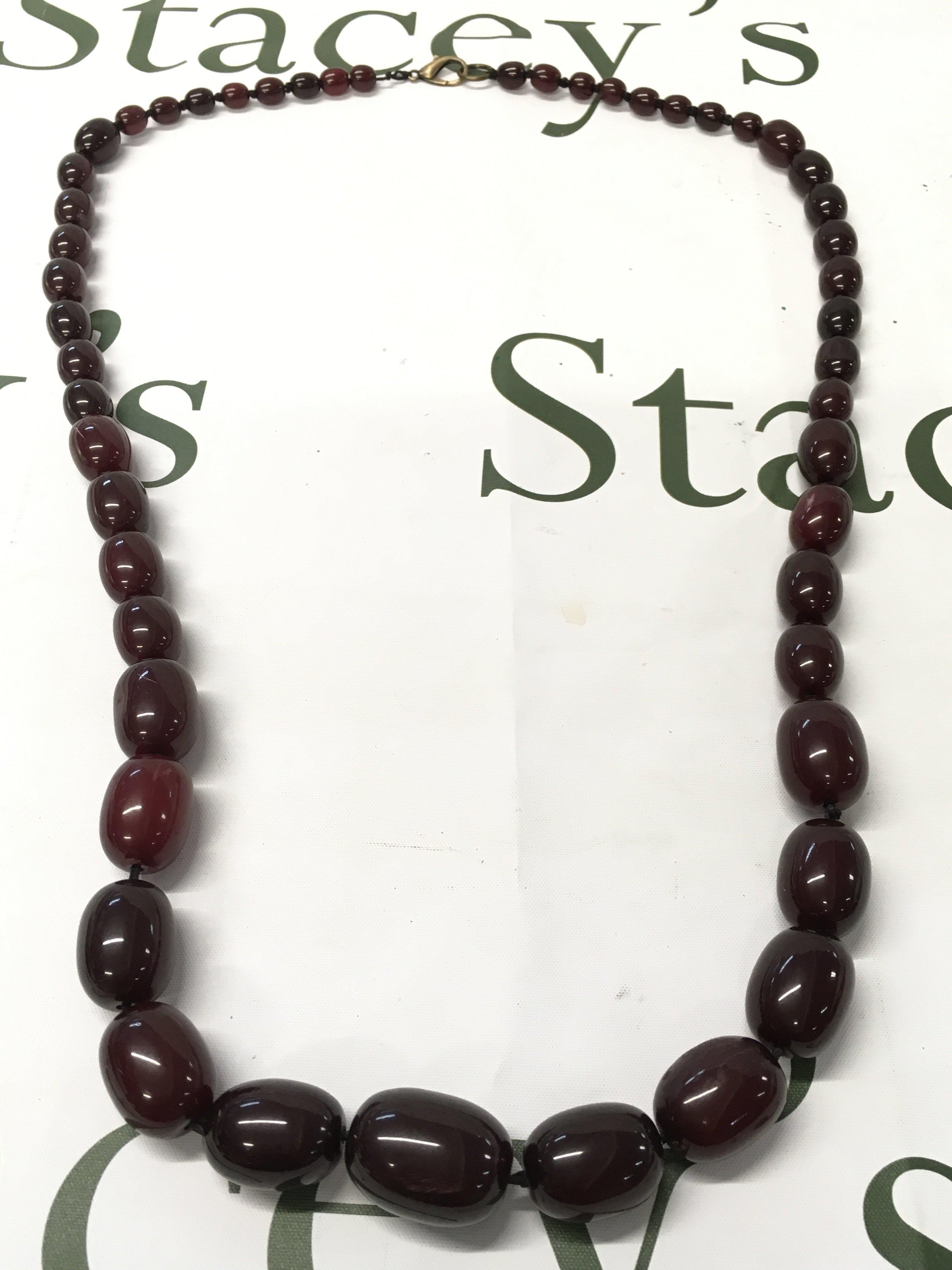 A large cherry amber bakelite necklace , 140g total weight, 98cm long. Postage category A