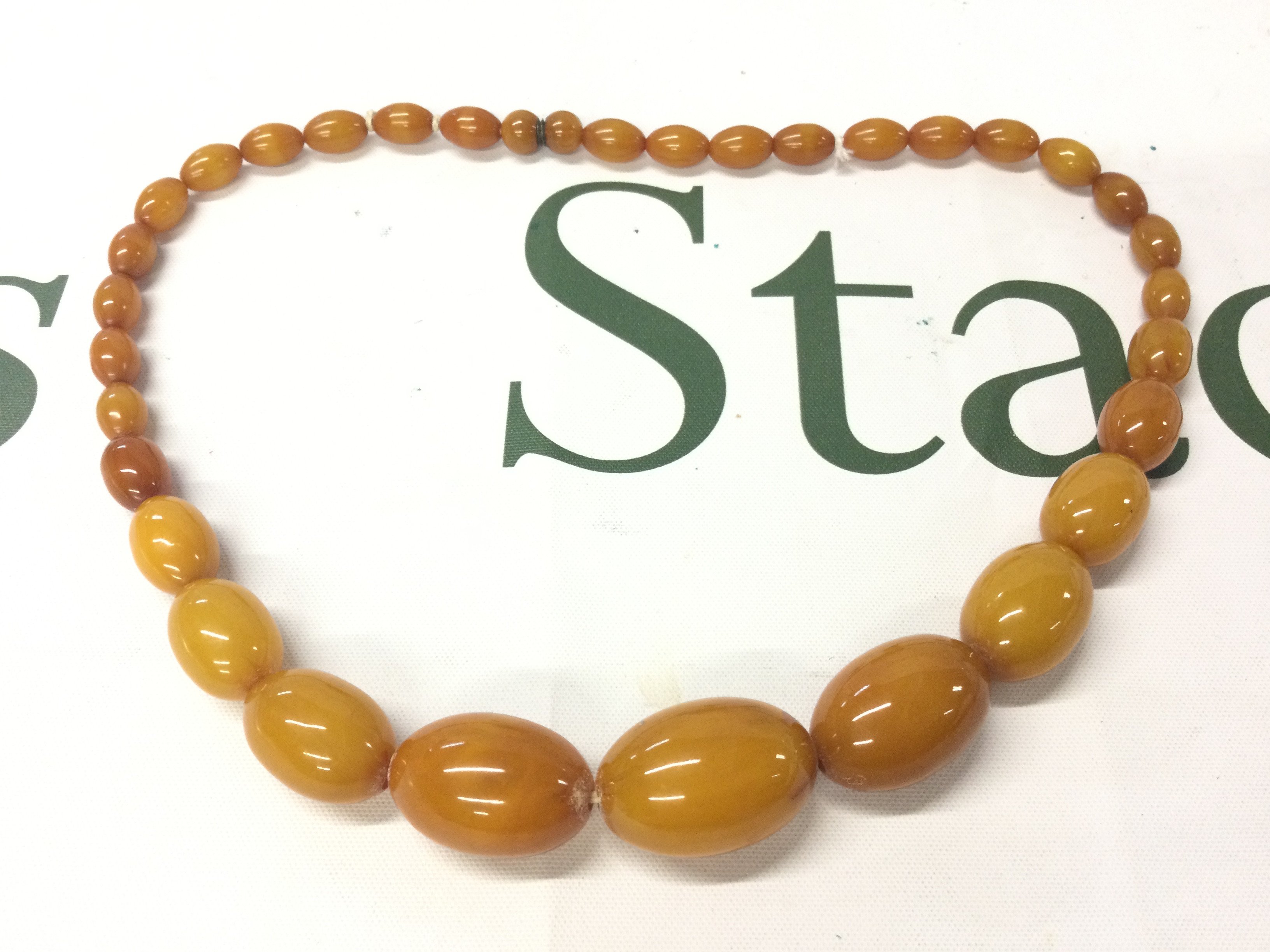 A Bakelite amber necklace , 48cm long. 46g total weight. Postage category A
