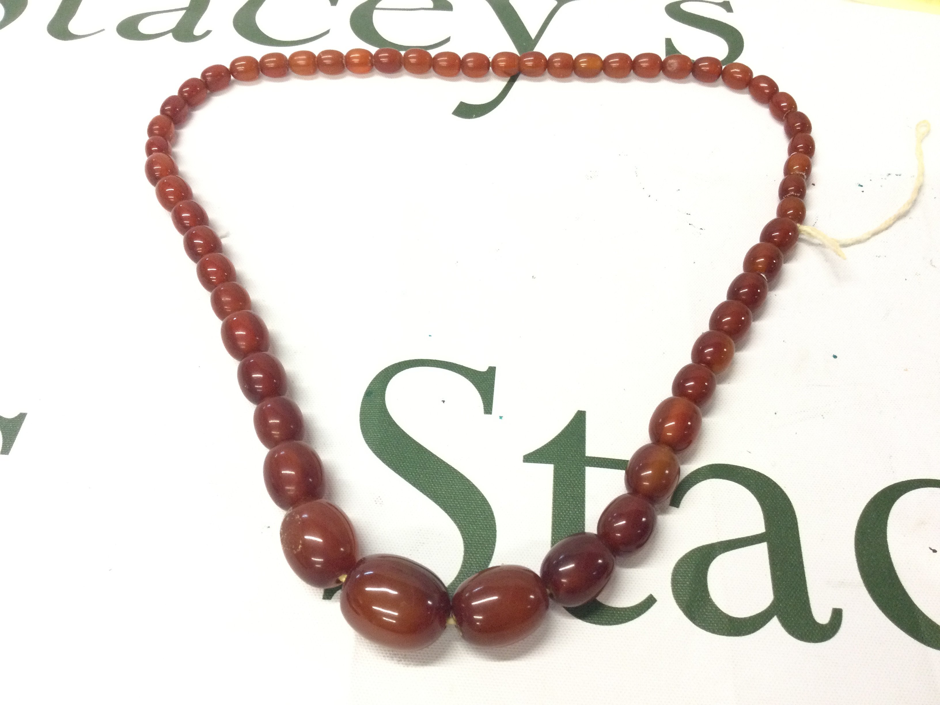 A Bakelite amber necklace , 60cm long . 45g approx weight. Postage catA