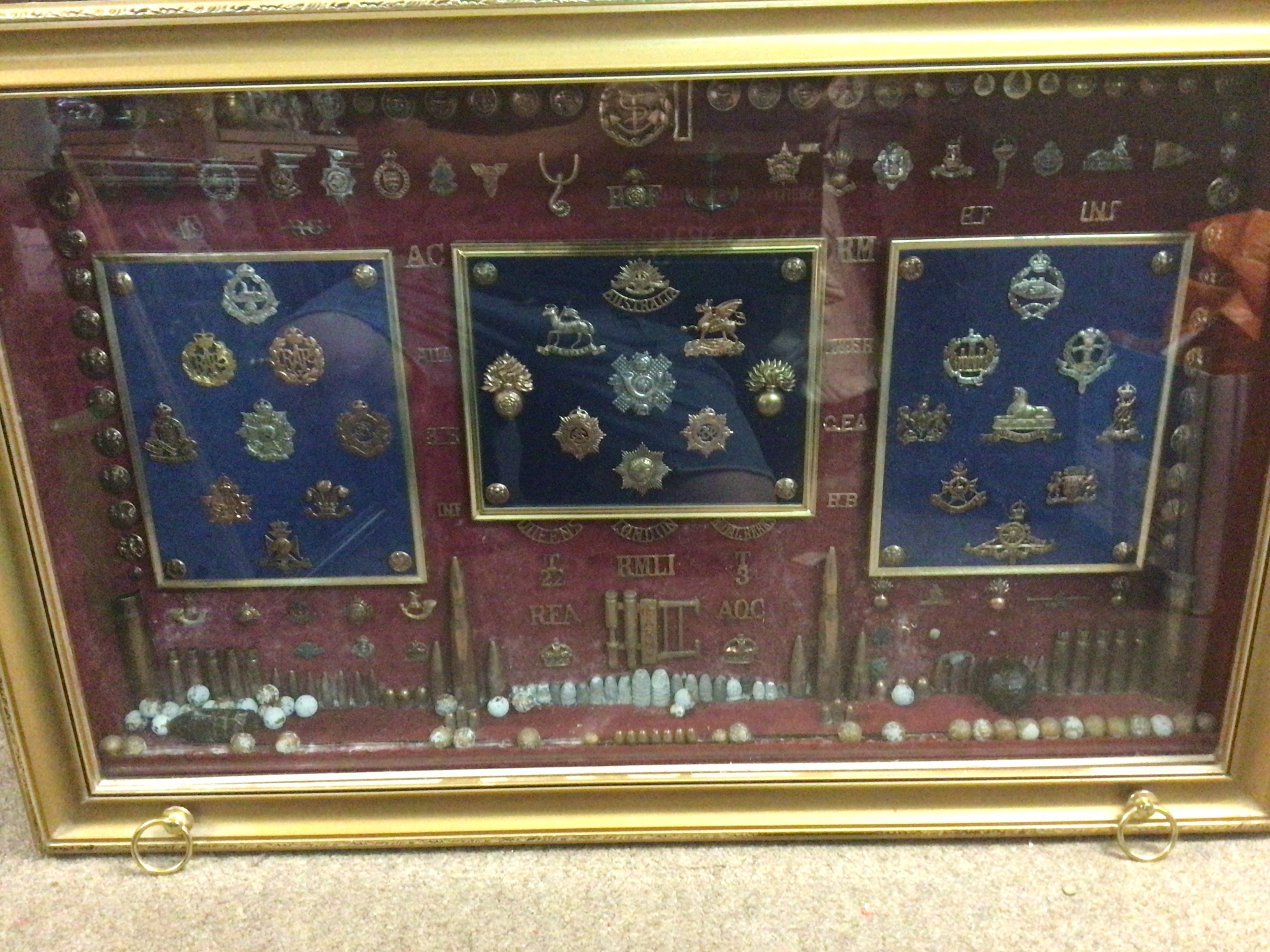 A case containing military badges, buttons , shells including a rare Canadian tank regiment badge. This lot cannot be posted