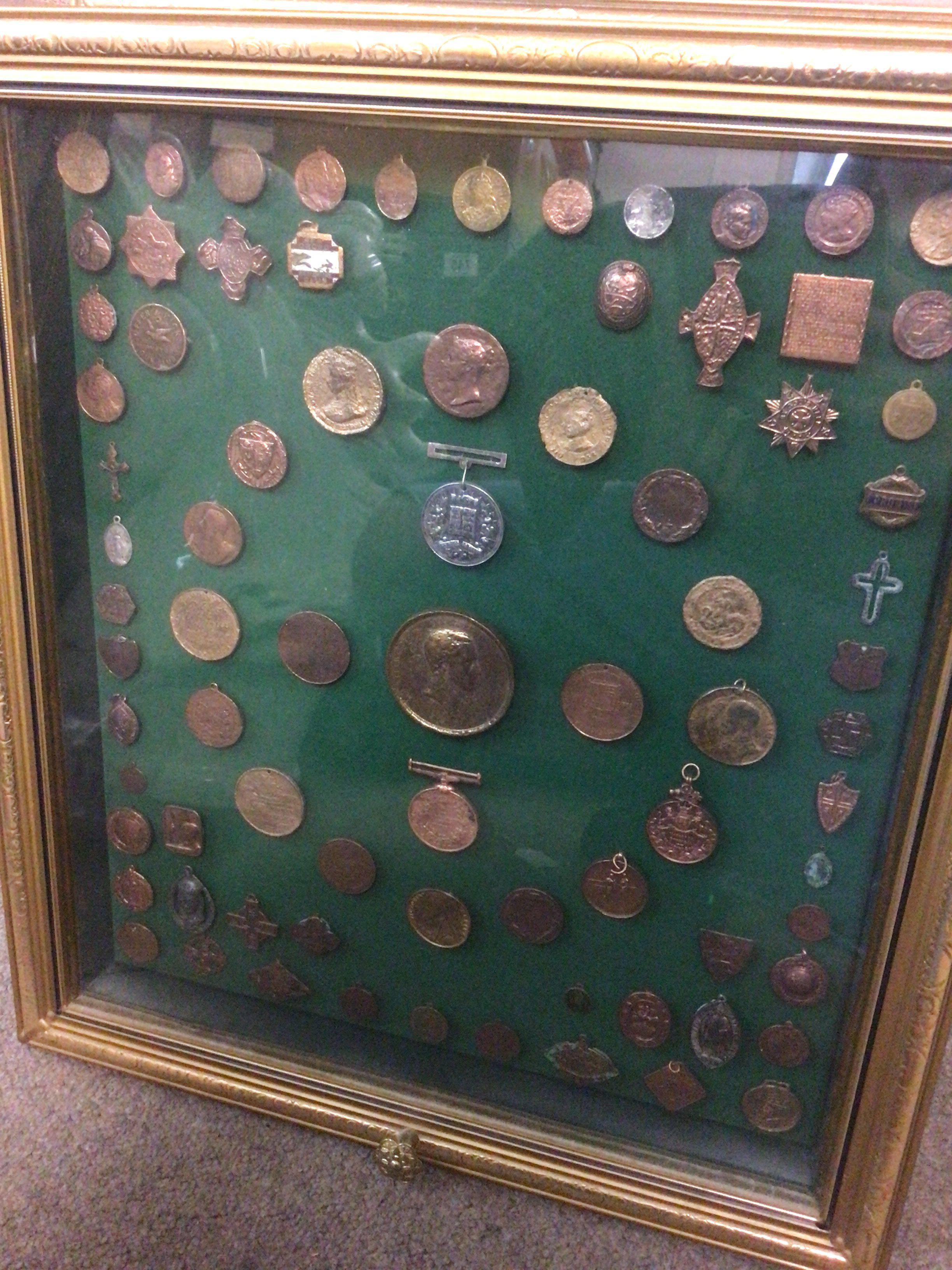 A case containing military medals, badges, coins and tokens . This lot cannot be posted