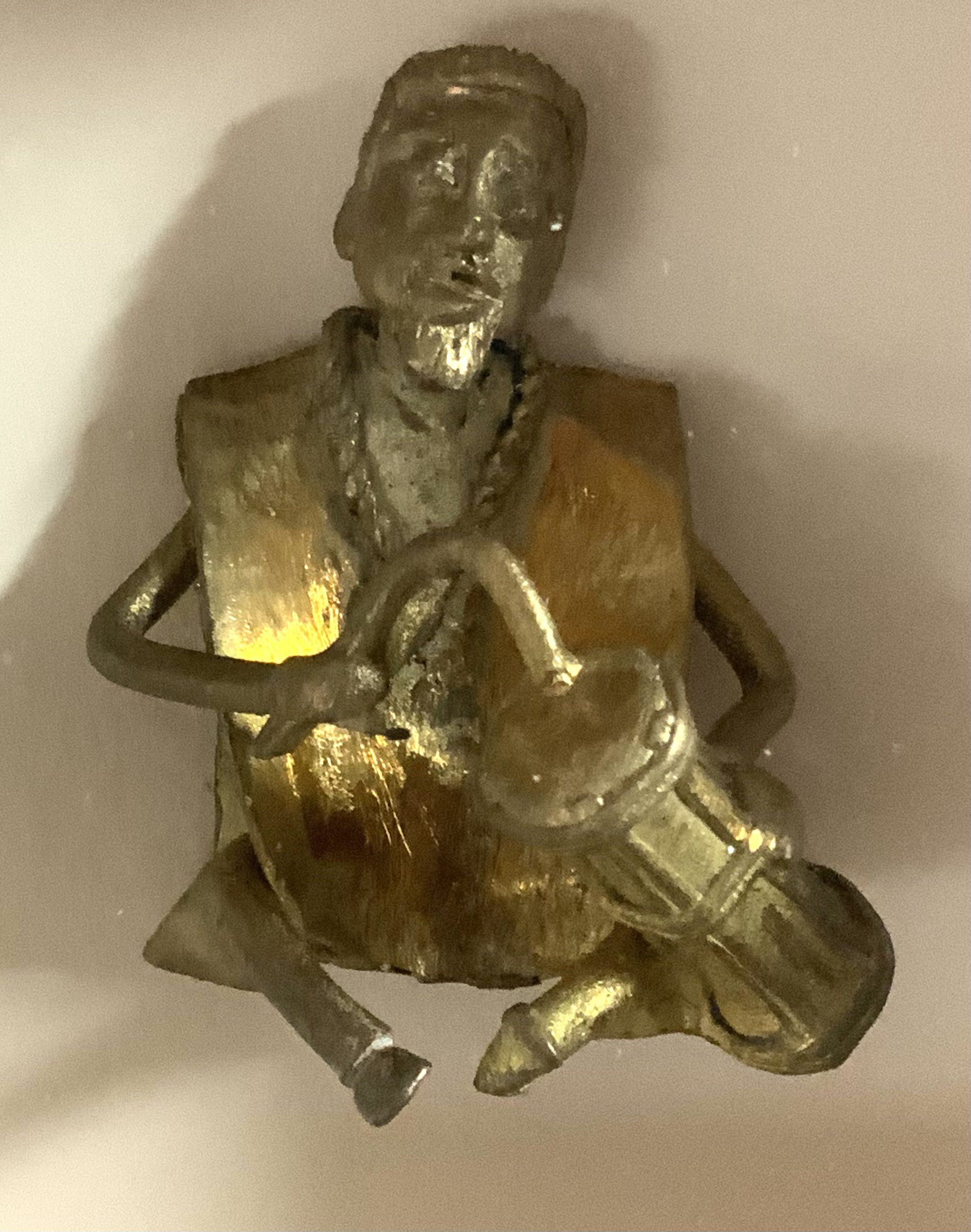 A small bronze West African seated figure of a man mounted within a shadow box display. (A) NO RESERVE