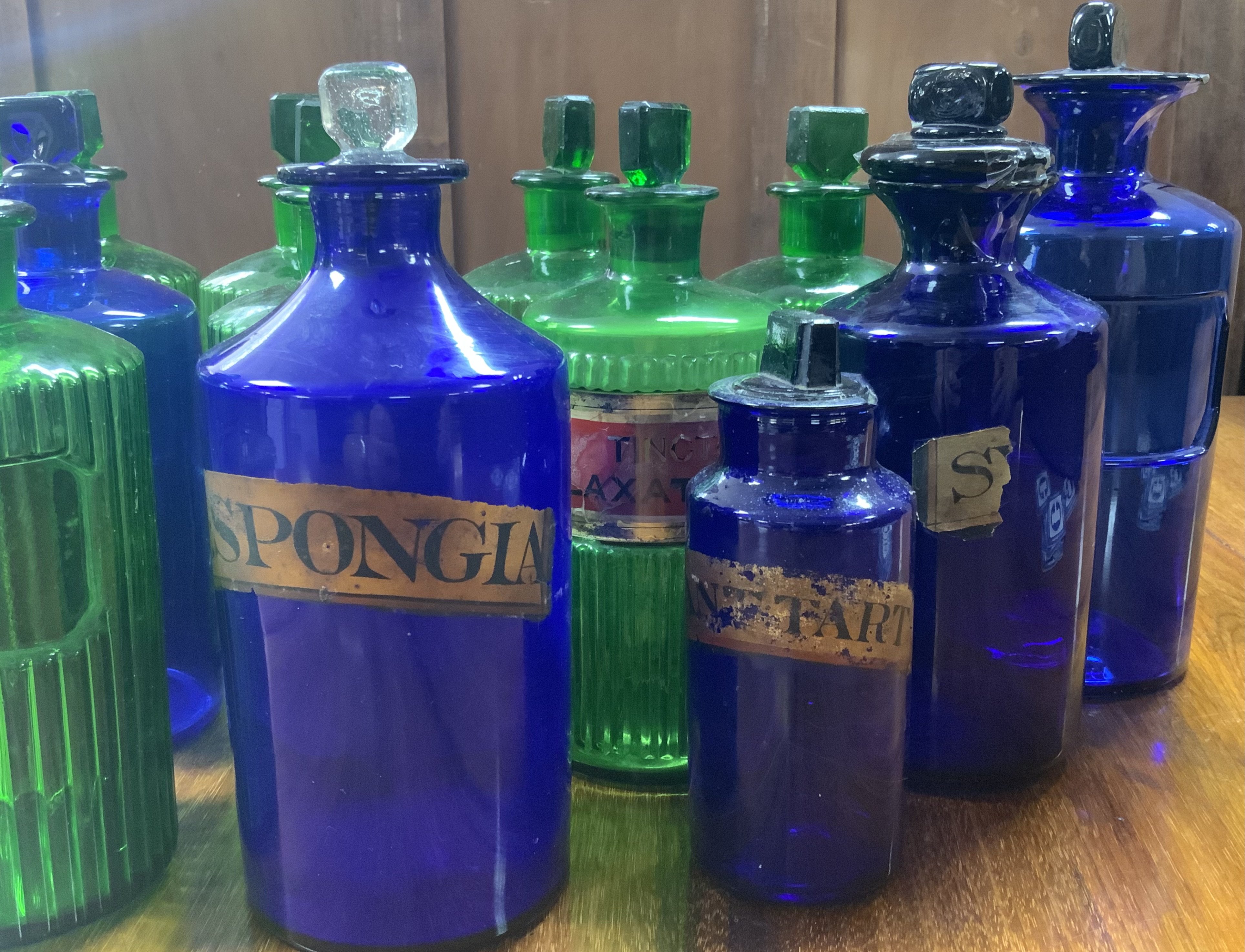A collection of 19th Century Bristol Blue and Green glass apothecary bottles. 14/20/21cm (D) some damage., partial labels