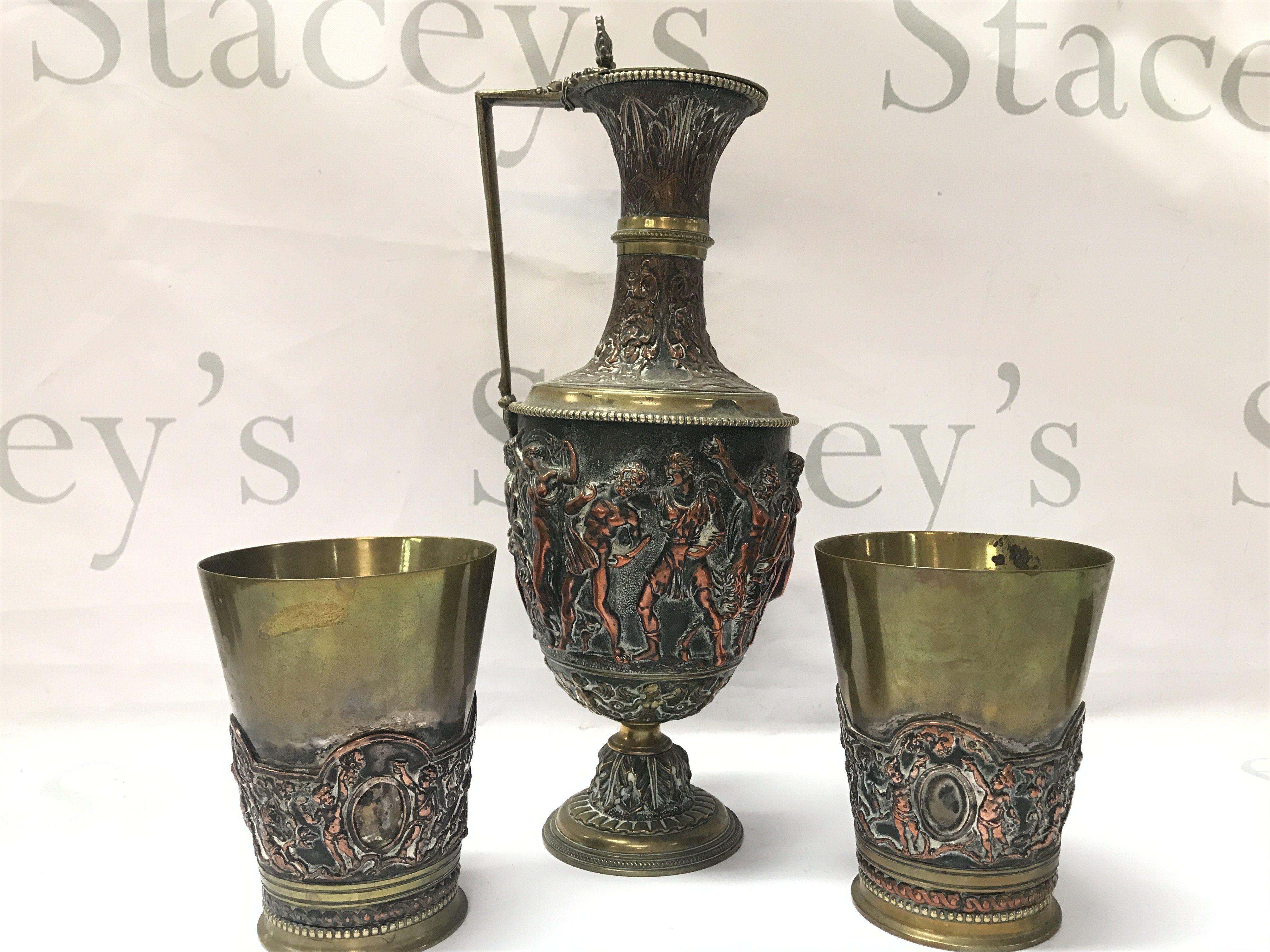 A Renaissance Revival Classical Ewer by JG & Sons (30cm tall approx) and a pair of matching goblets decorated with figures. (11.5cm tall)