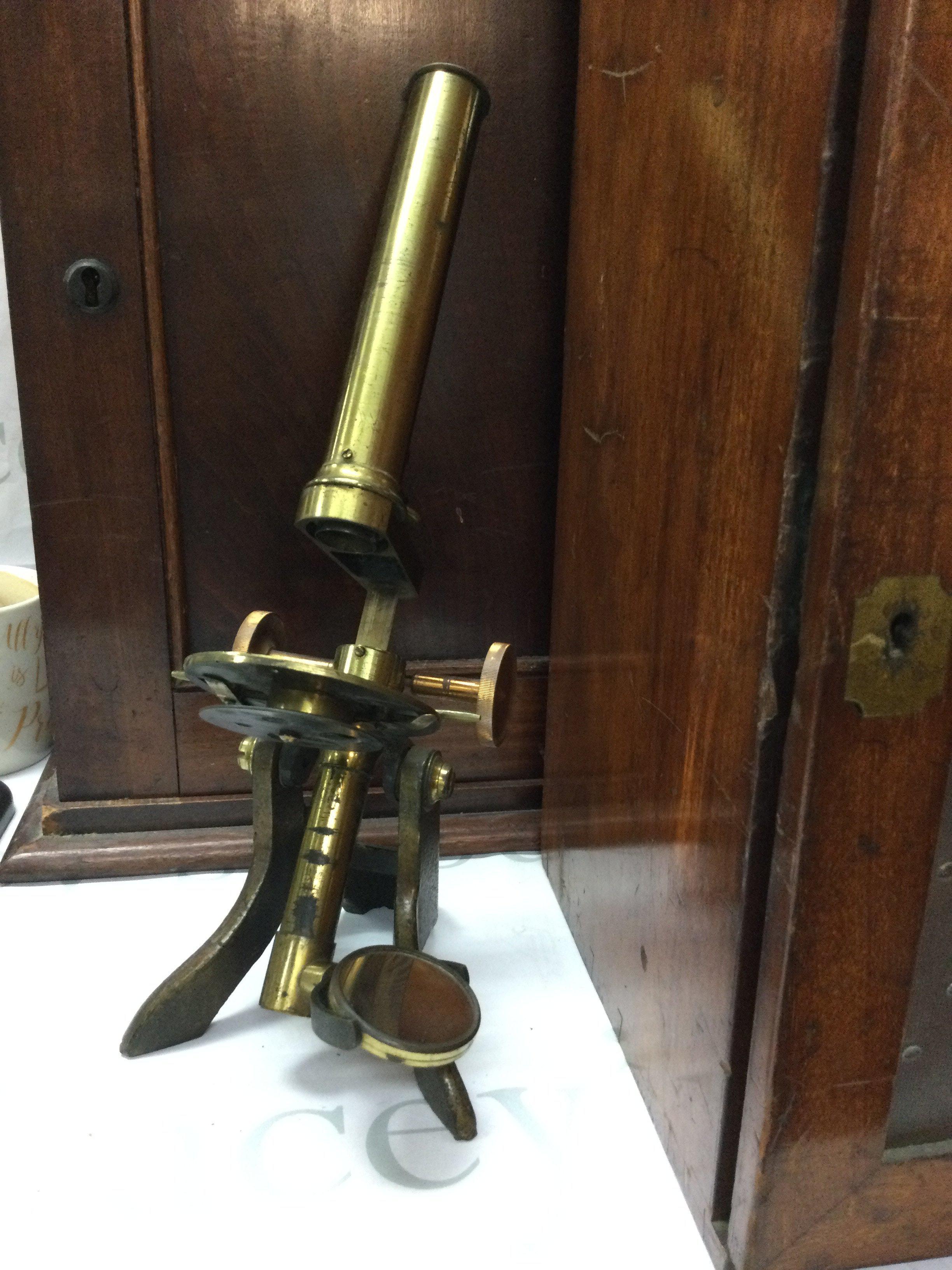 A cased brass Monocular together with a mahogany cabinet fitted with numerous specimen slides one other brass Monocular and a smaller case of slides.