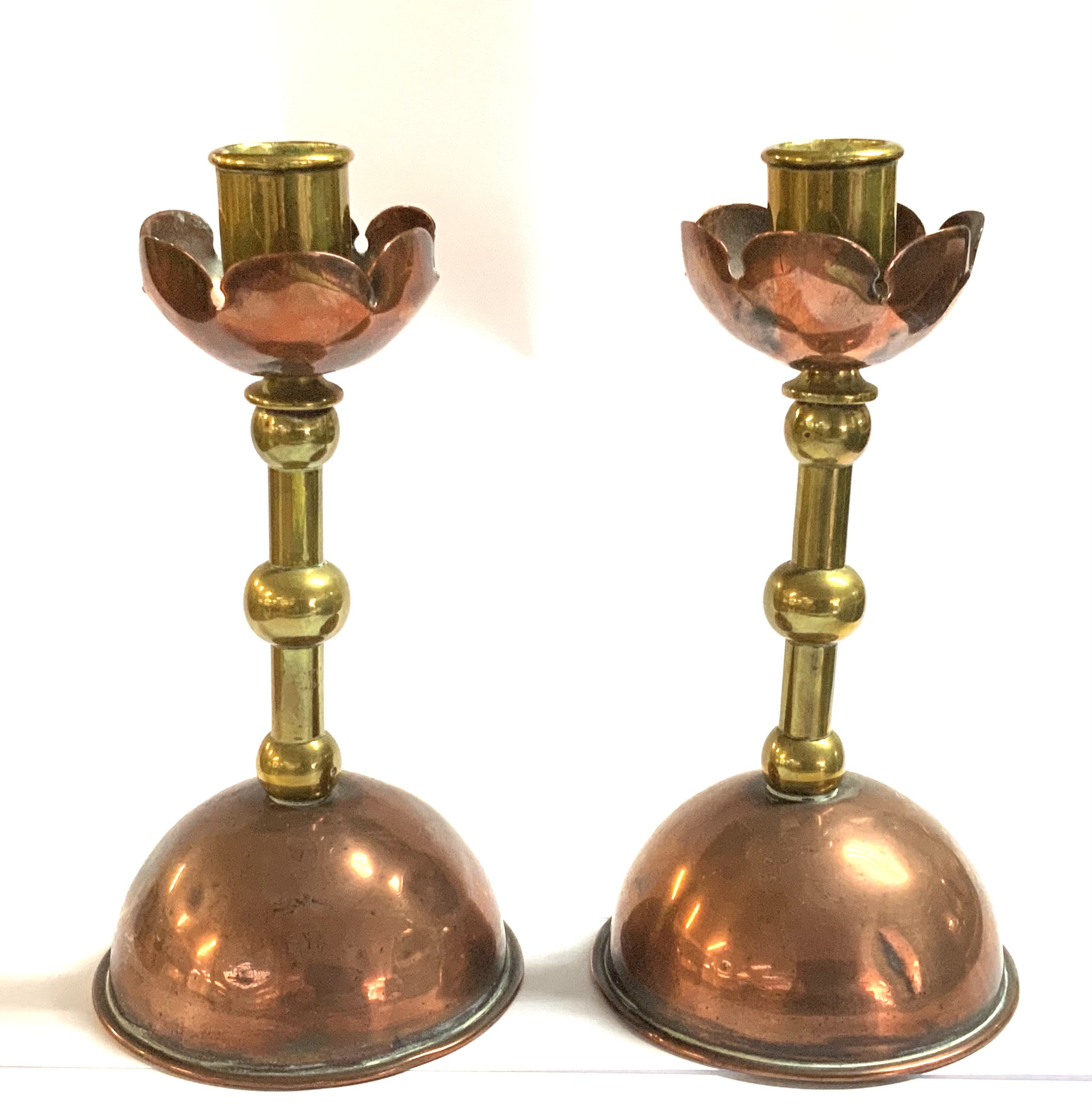 A Pair of Arts and Crafts copper and brass candlesticks in the manner of Christopher Dresser. 19cm.