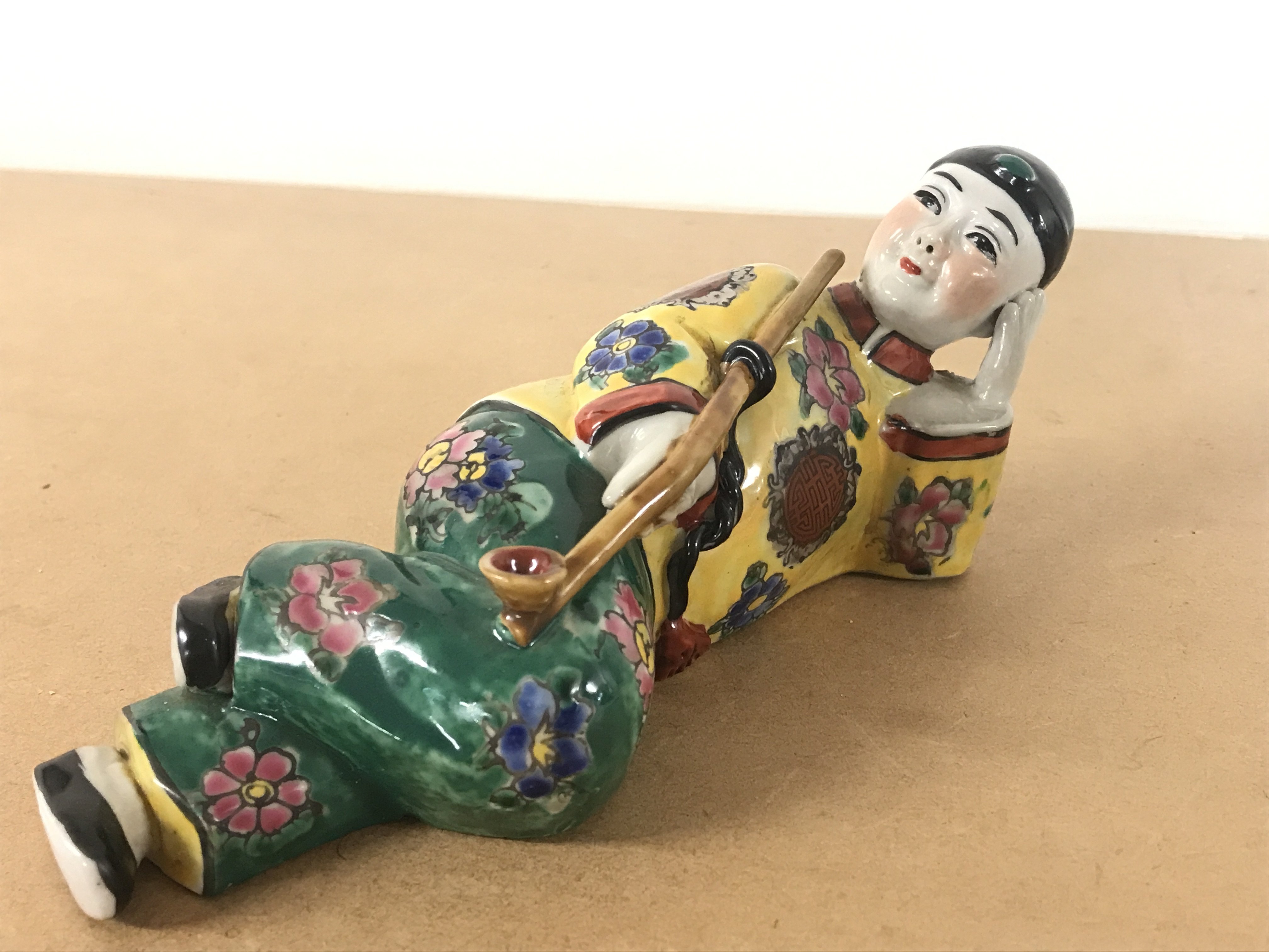 A Chinese Opium smoker porcelain figure 7.5cm tall 19.5cm long. Four character mark to base. This lot cannot be posted