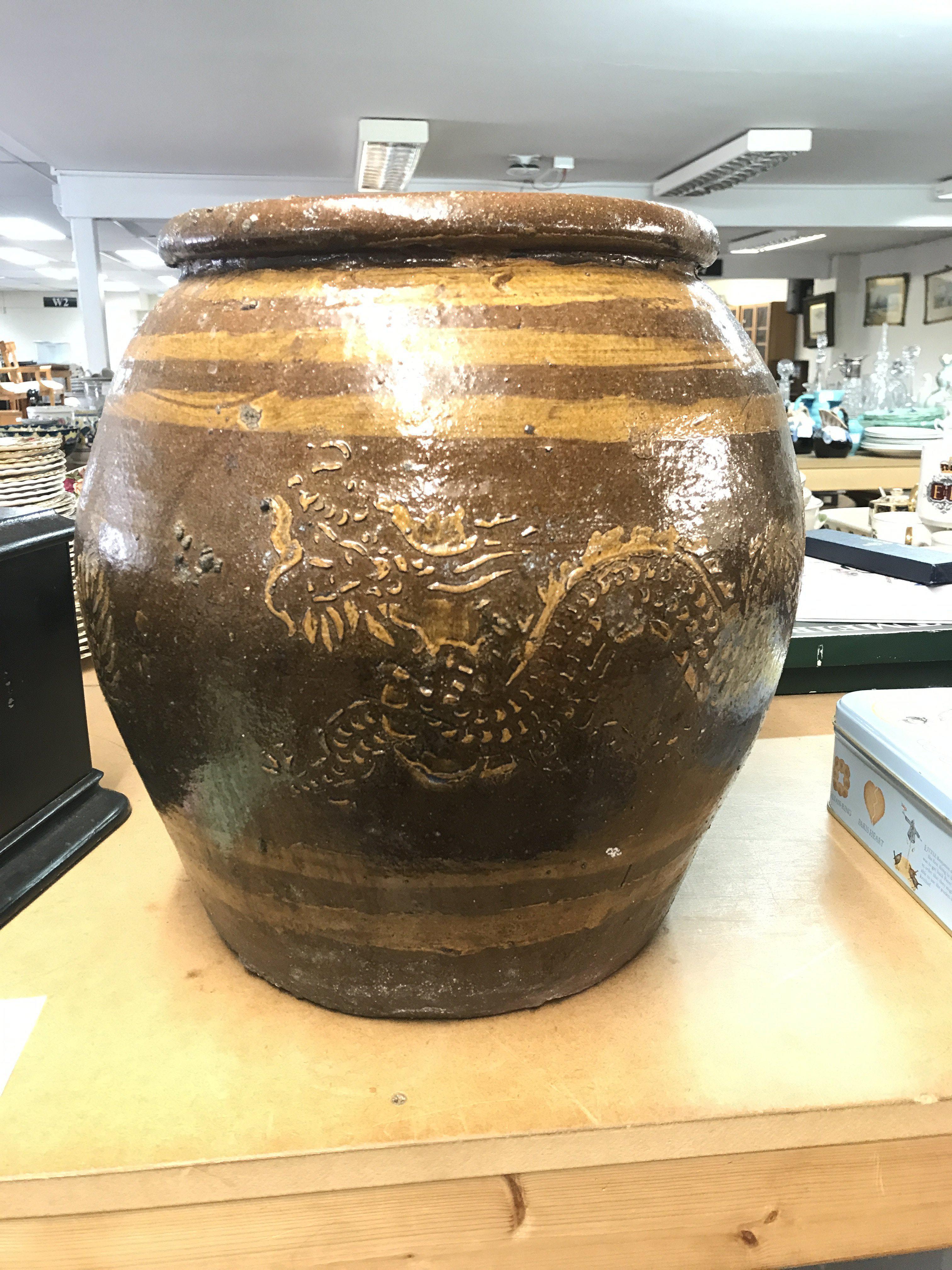A large Chinese pottery plant pot decorated with dragons on a brown ground, 35cm tall. This lot cannot be posted