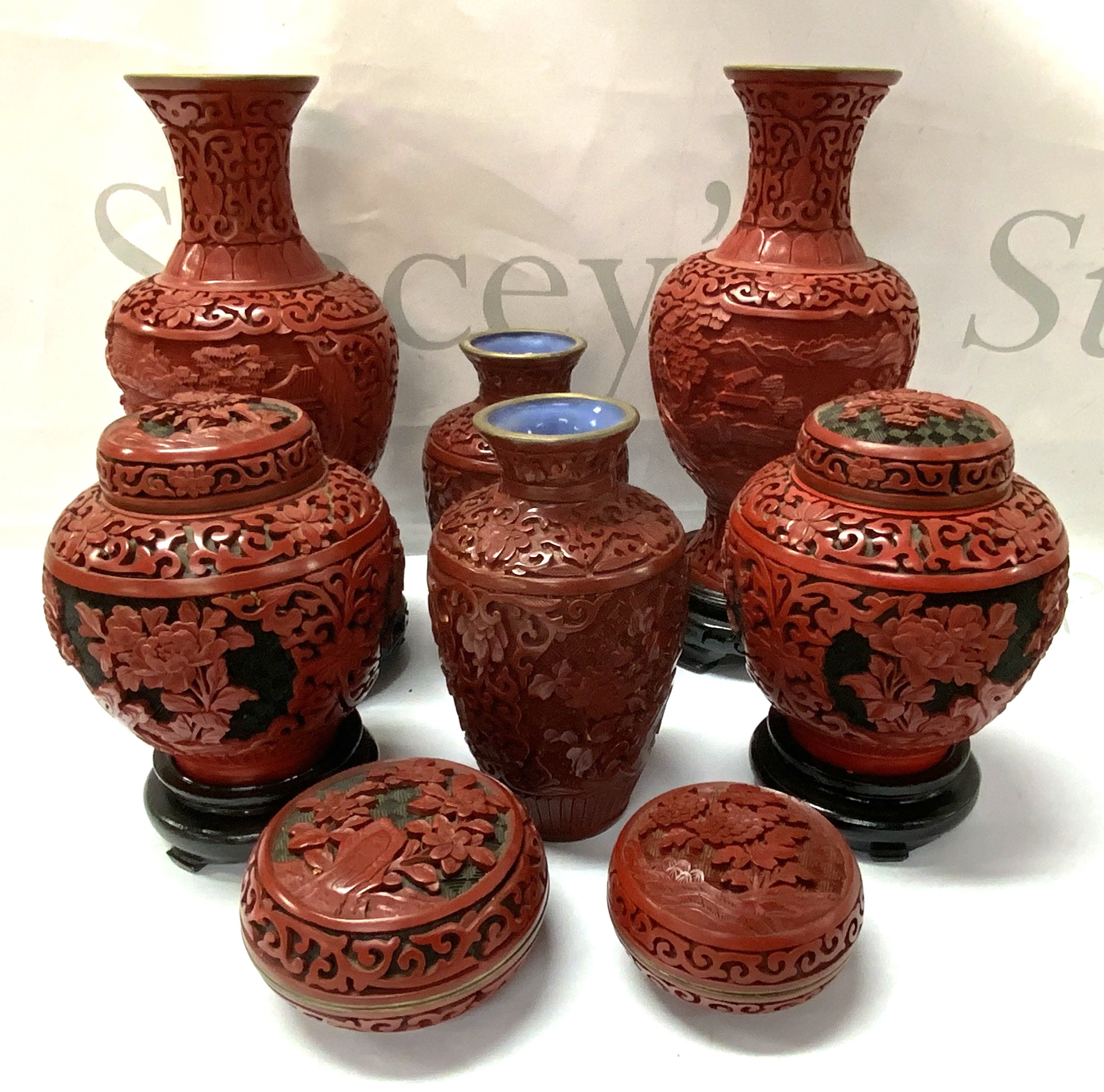 A collection of carved cinnabar vases.