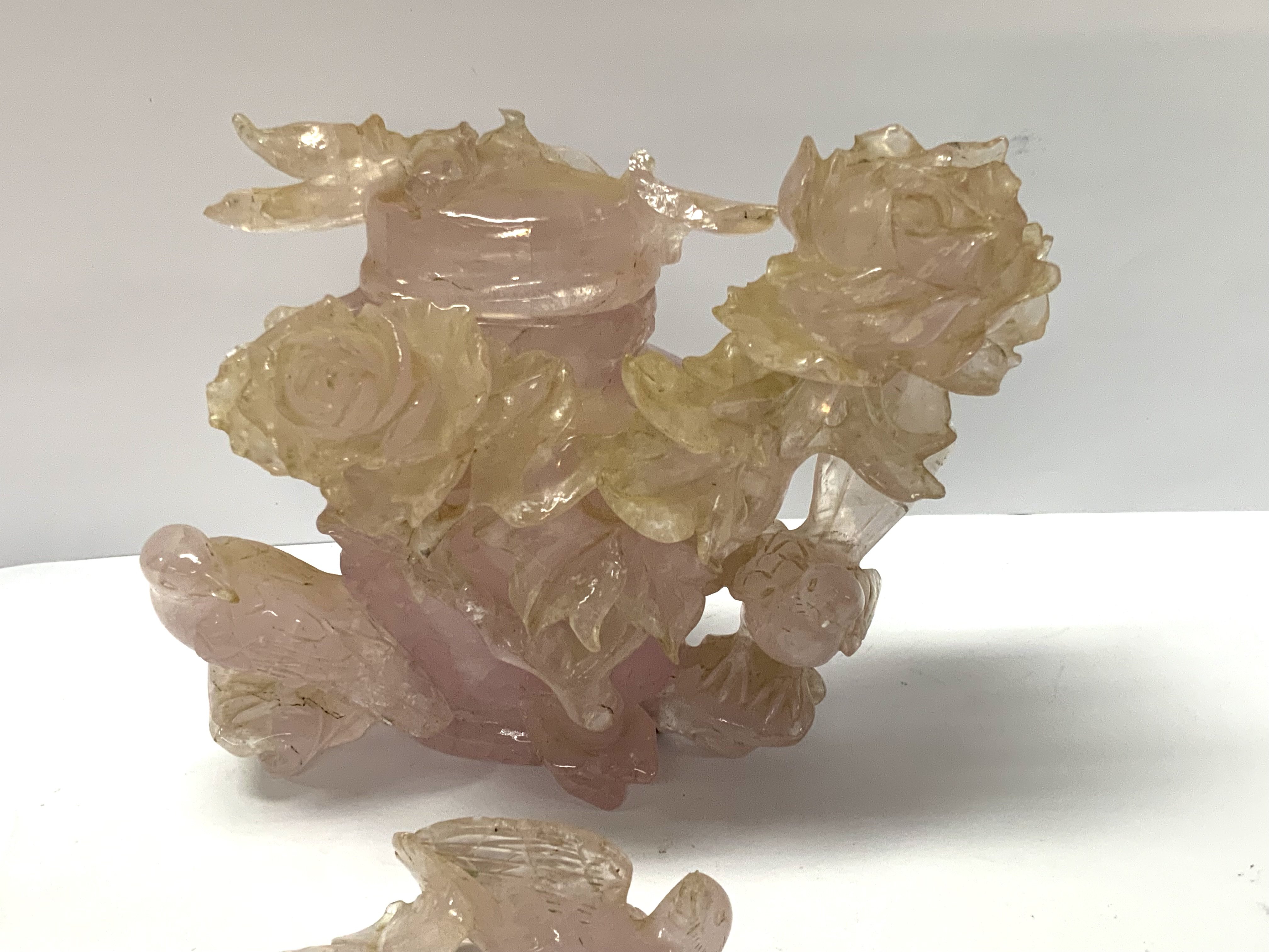 A carved Rose Quartz carved lidded pot with rose and bird decoration. (A/F)