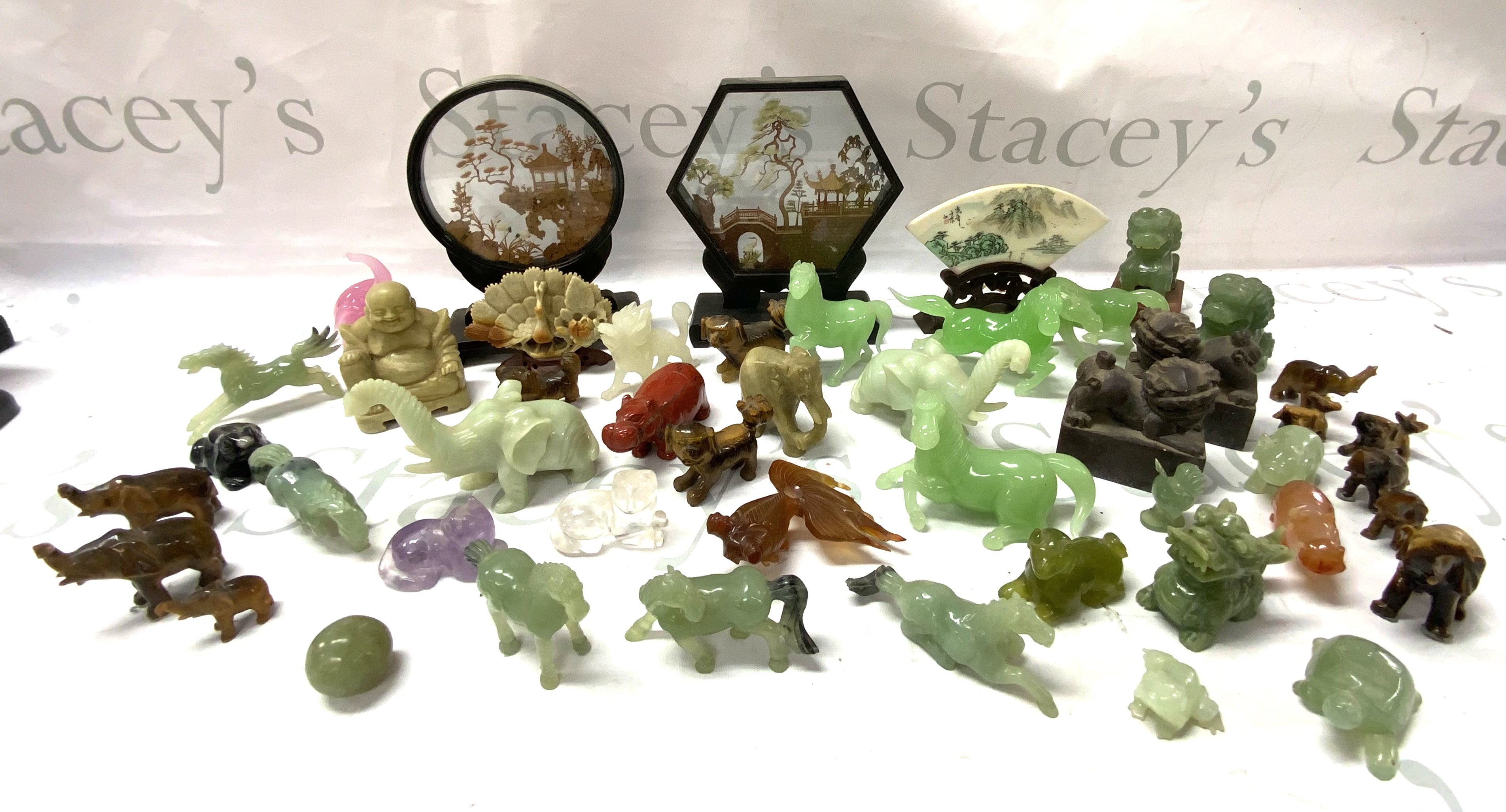 A large collection of carved jadeite and soapstone figures.