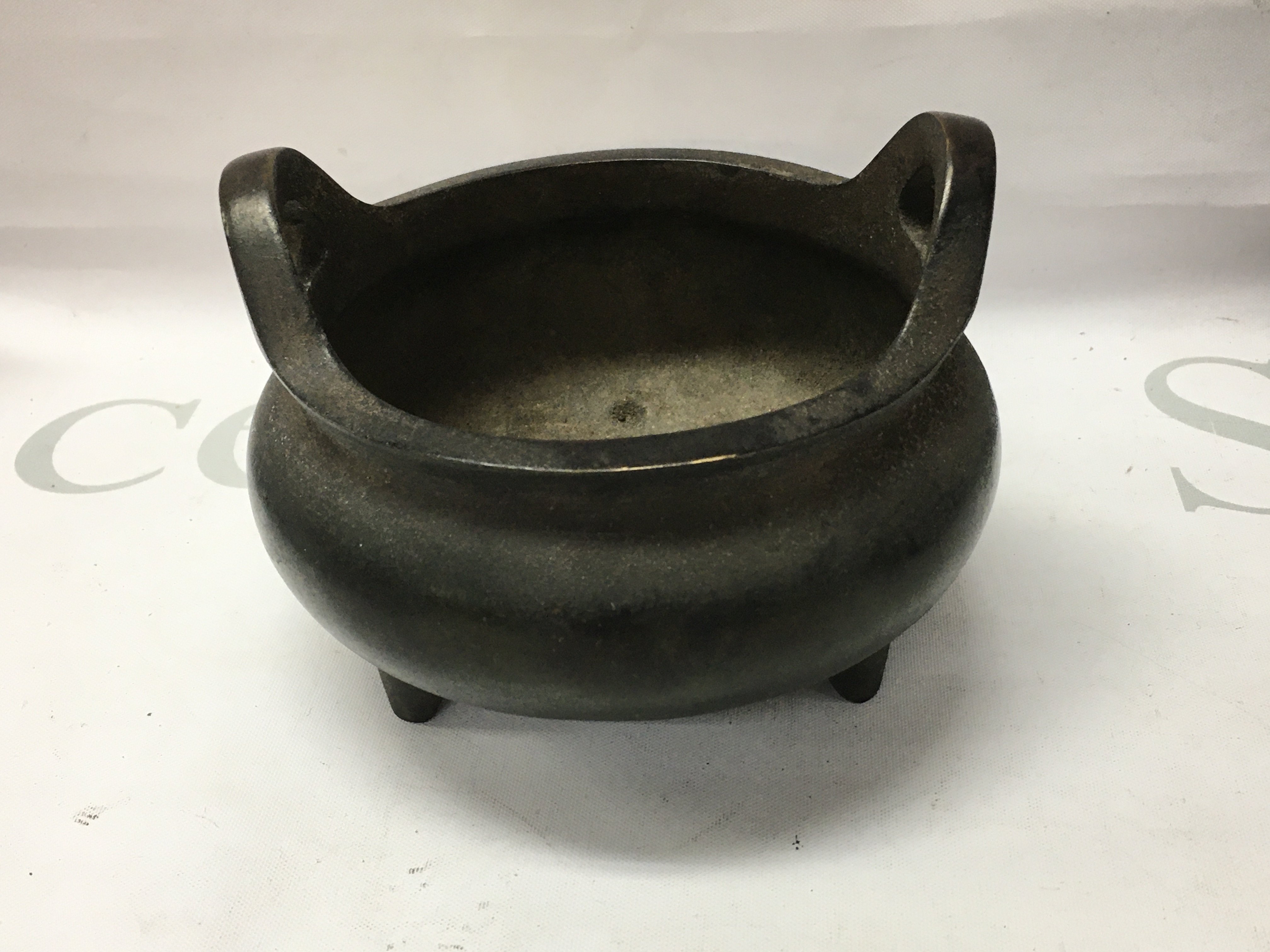 A Chinese bronze censer with twin handles marked to the base DE Xuan . 10 cm .