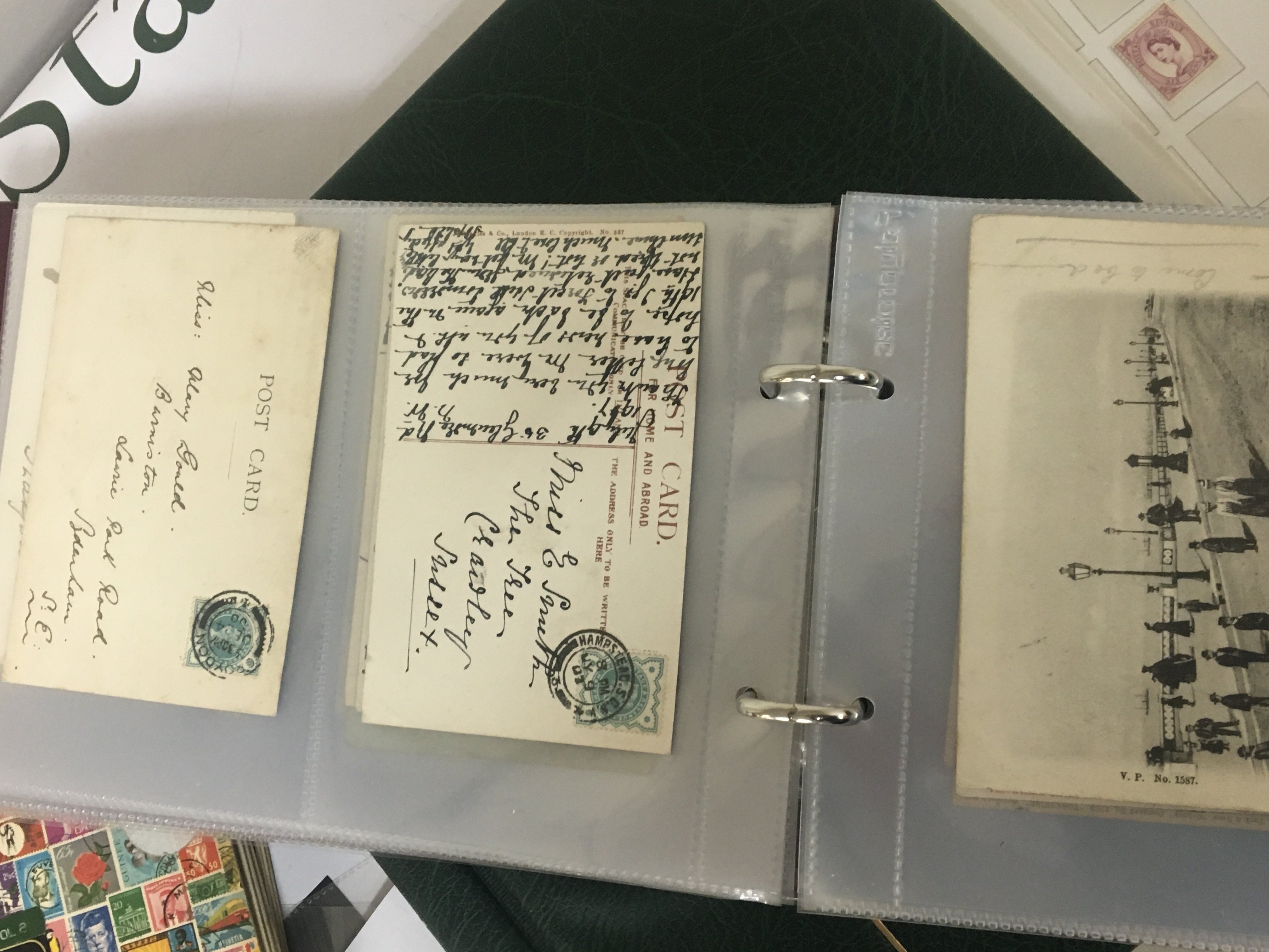 An album containing a good collection of Victorian postcards two Stamp collectors stock books and an album containing Elizabeth II stamps used and unused including pre-decimal stamps.