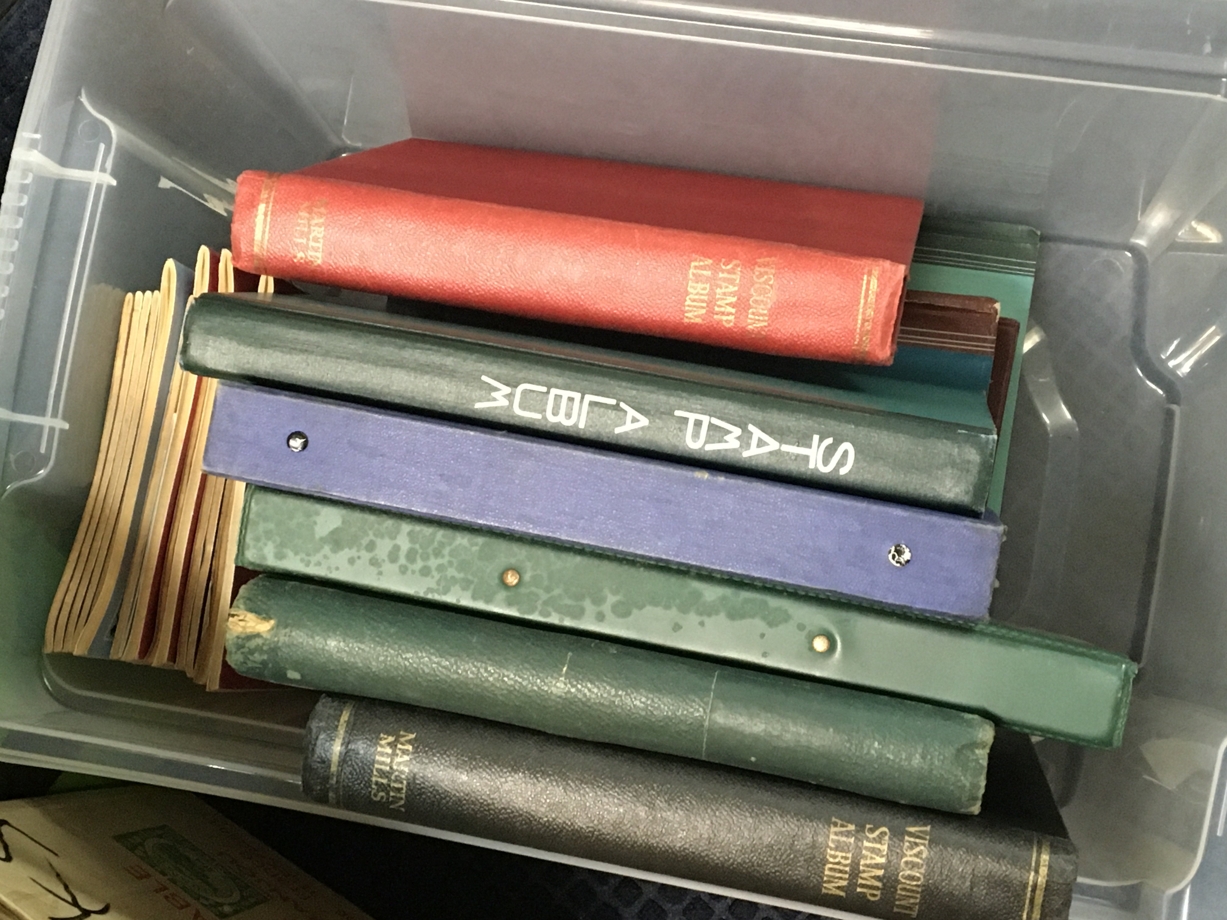 A box containing several albums of mixed world stamps.